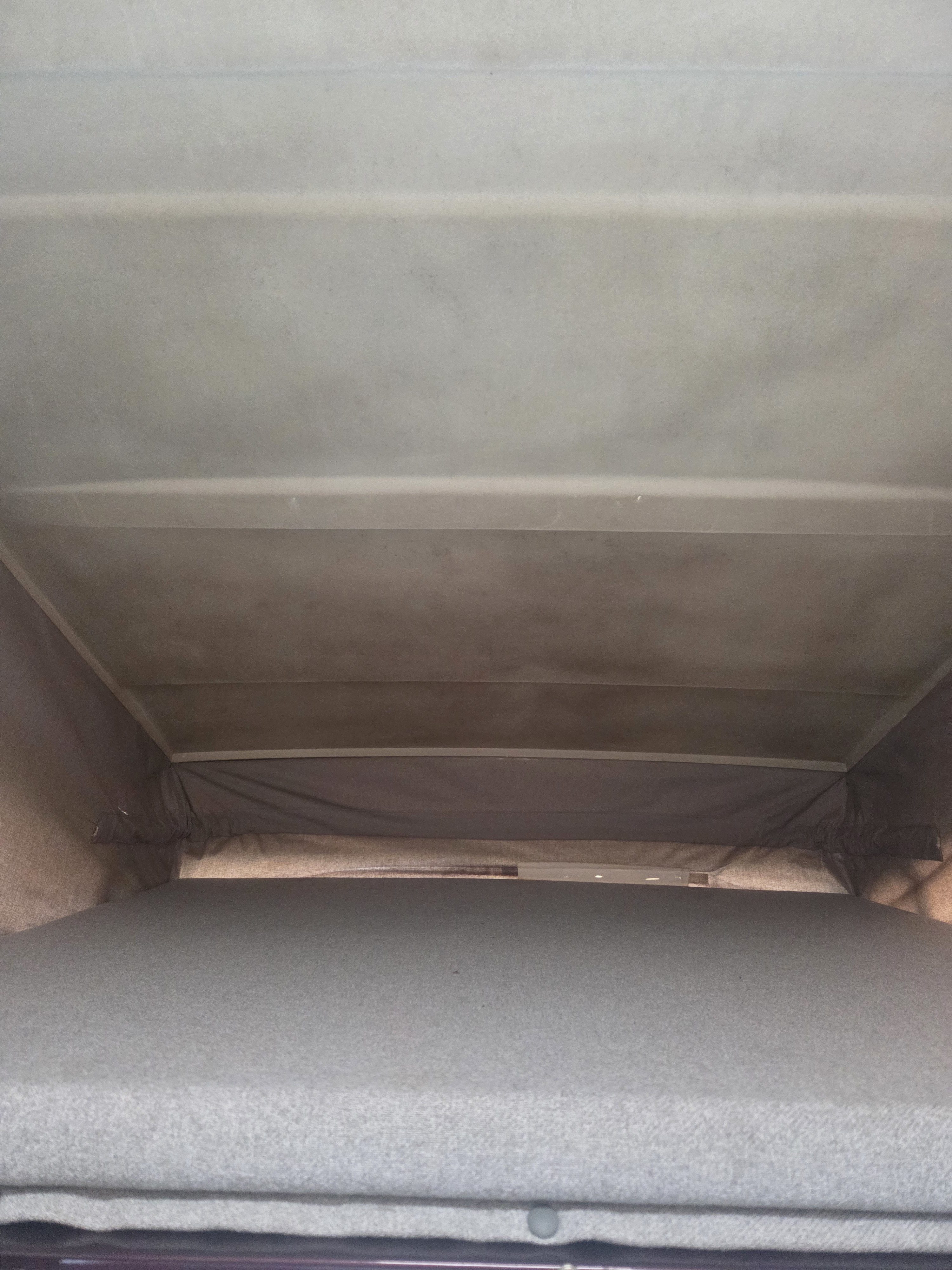RV rental interior: View of the light-colored pop-top roof with support beams and the gray sleeping platform below.. Westfalia T3 Westfalia 1991