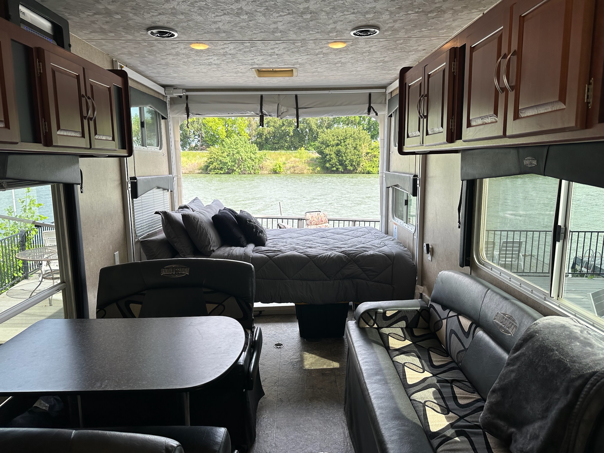 Enjoy lake views from this well-appointed RV rental interior, featuring a bed, dining, and lounge area.. Forest River Sandstorm 2012