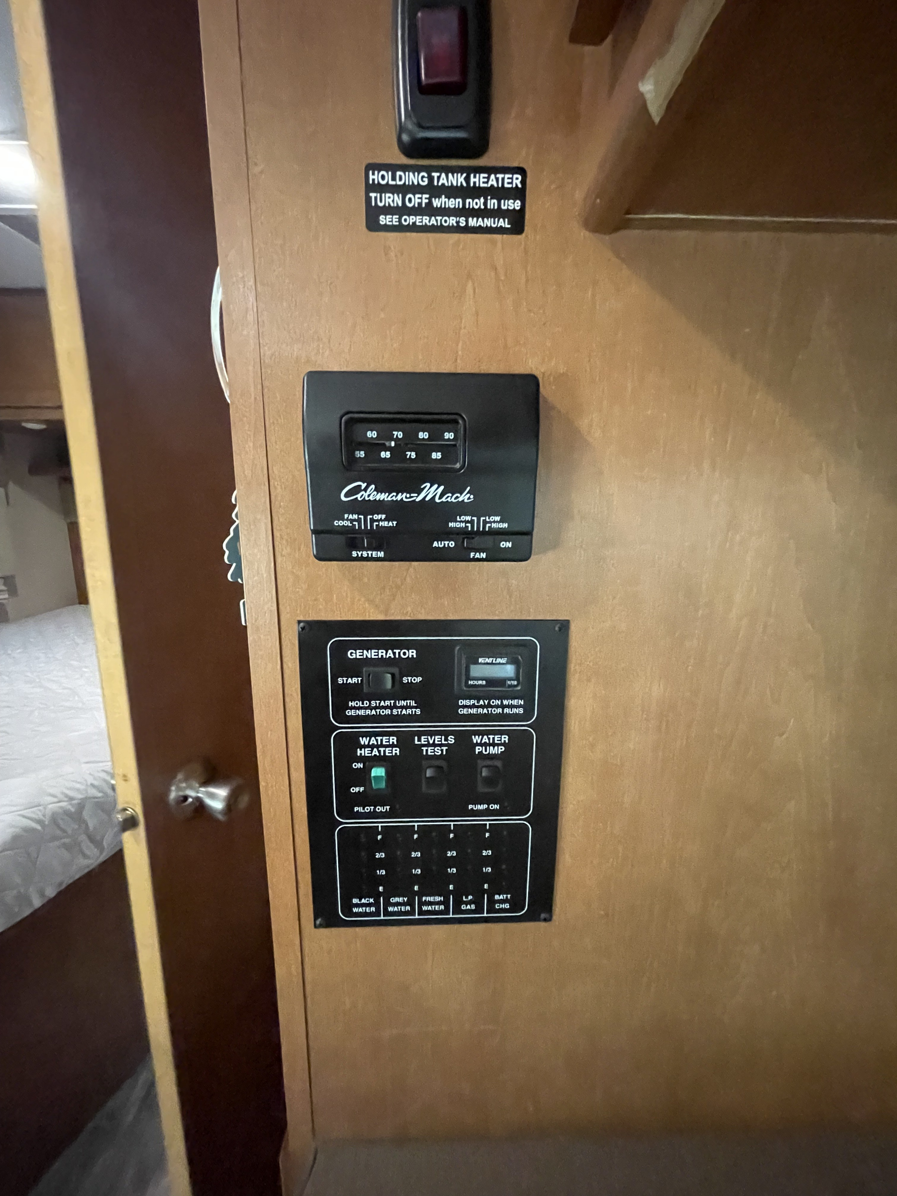 RV rental control panel: thermostat, generator controls, water heater switch, tank level indicators, and water pump switch.. Winnebago Minnie Winnie 2016