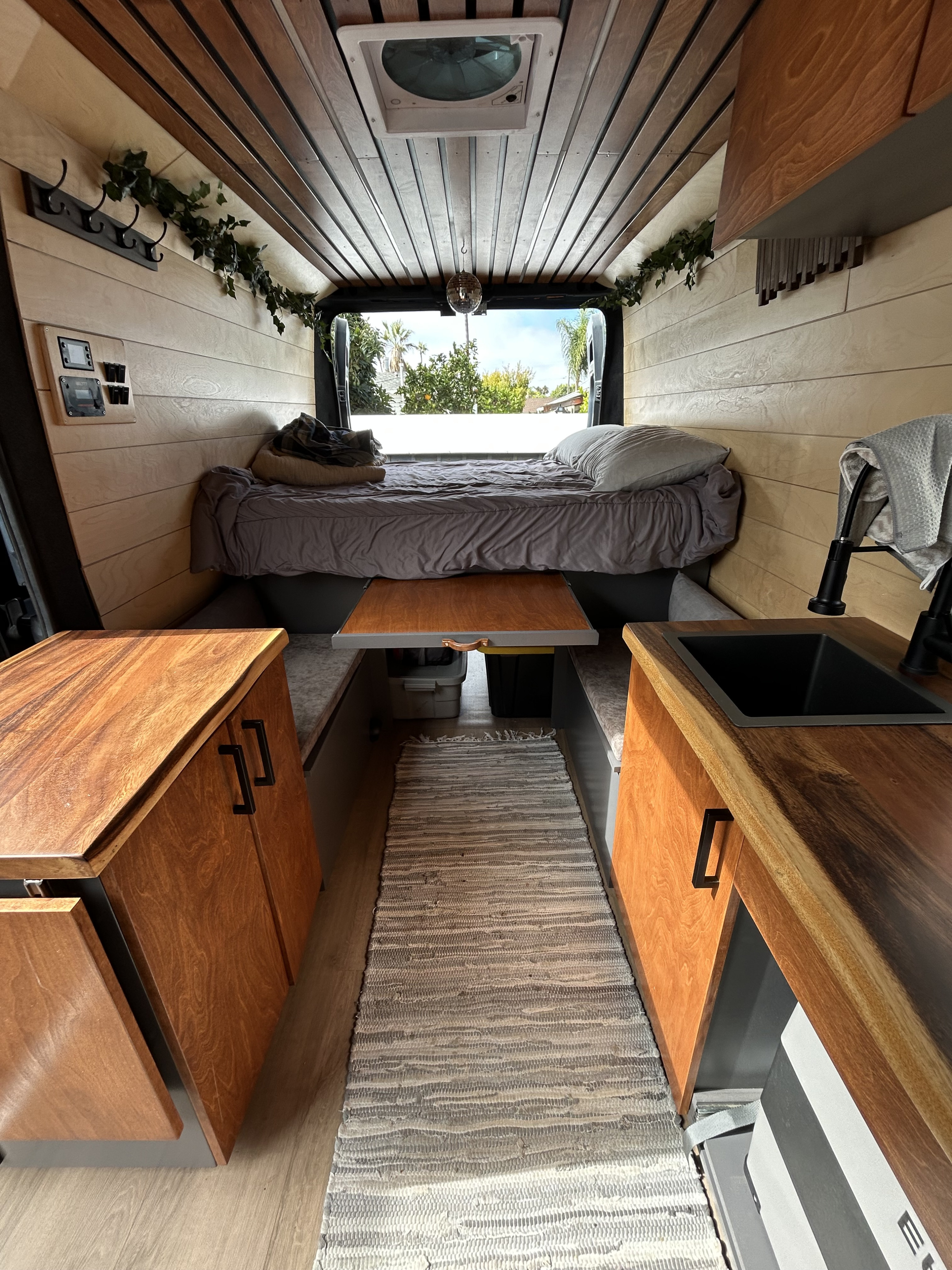 Step inside this modern RV rental! Features a compact kitchen, bed, and smart storage in a beautifully designed camper van interior.. Dodge Ram Promaster 2500 2019