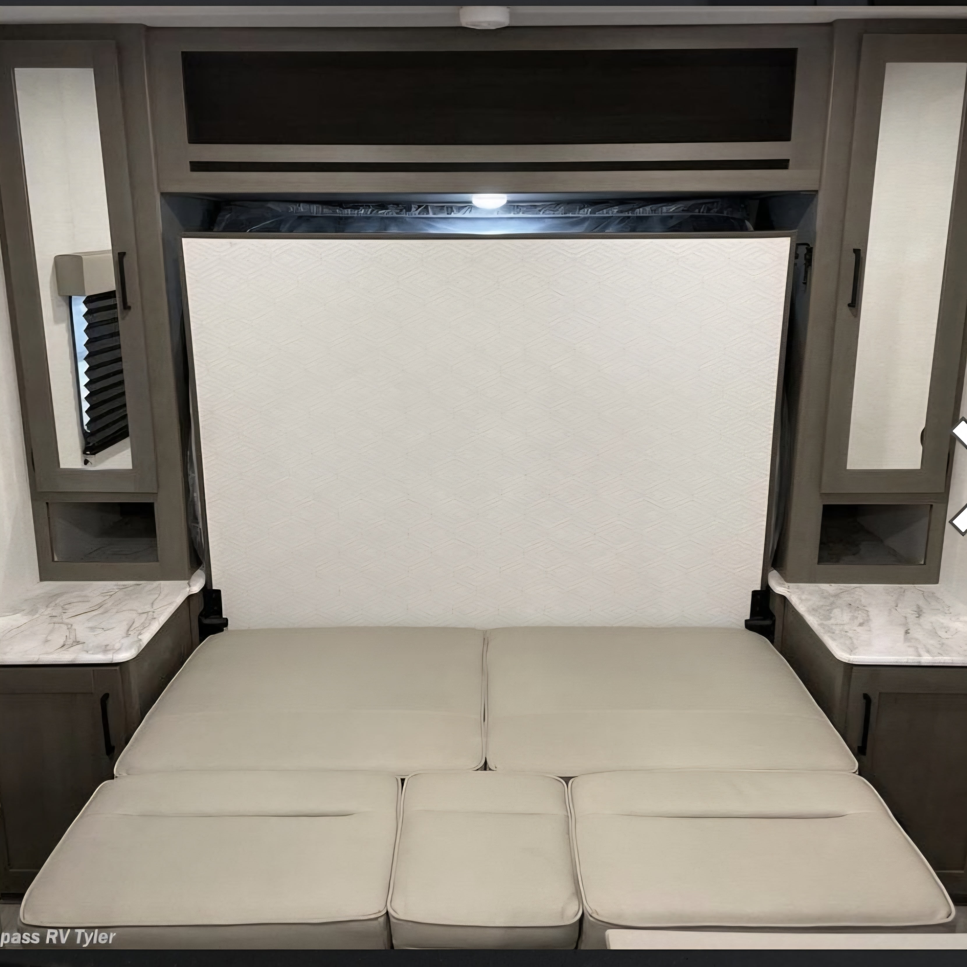 RV rental: Versatile interior showing a Murphy bed folded up, revealing a sofa. Maximizes space for day and night use.. Grand design transcend one 151rb 2025