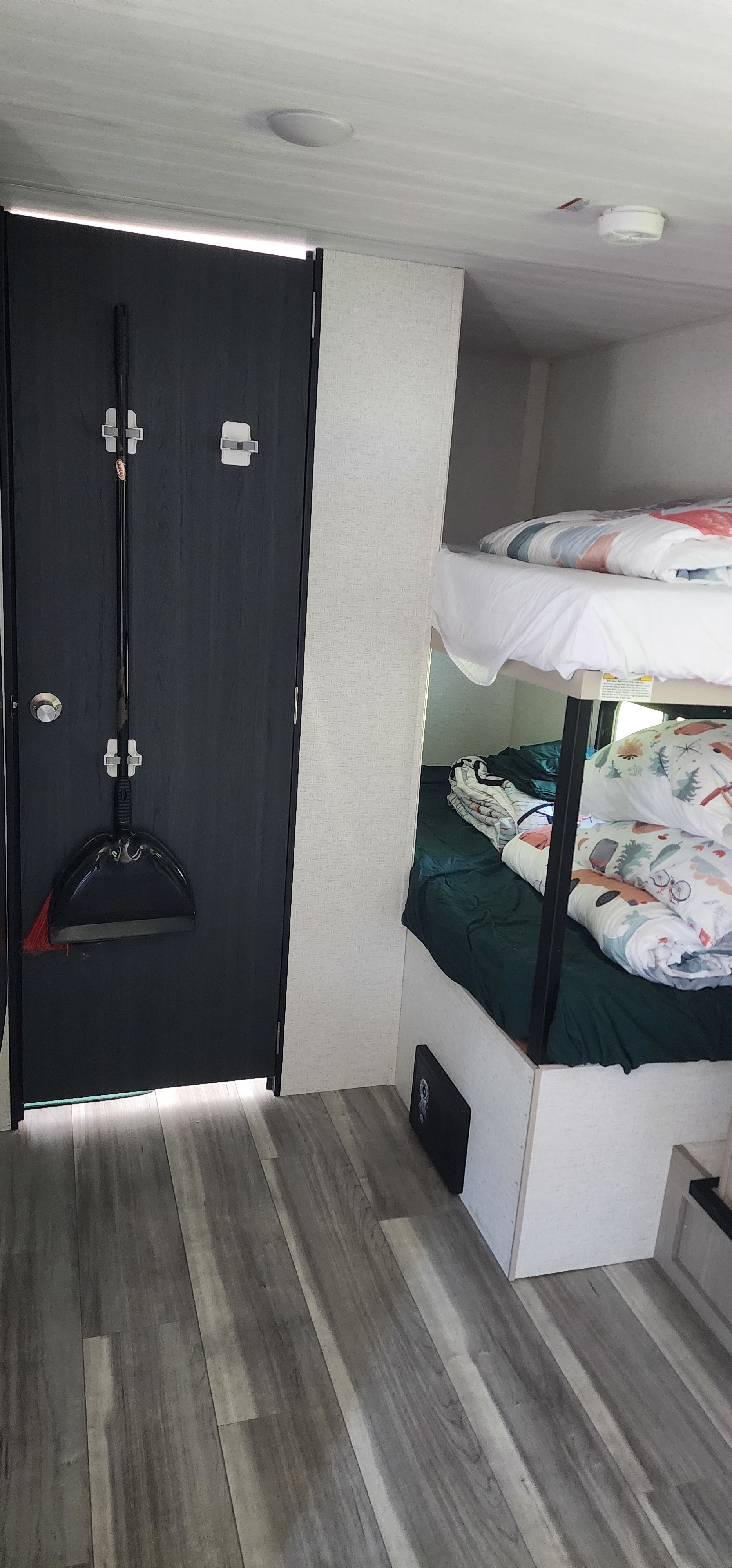 RV rental interior with bunk beds, compact storage, and wood-look flooring for travel comfort.. Keystone RV Springdale 2024