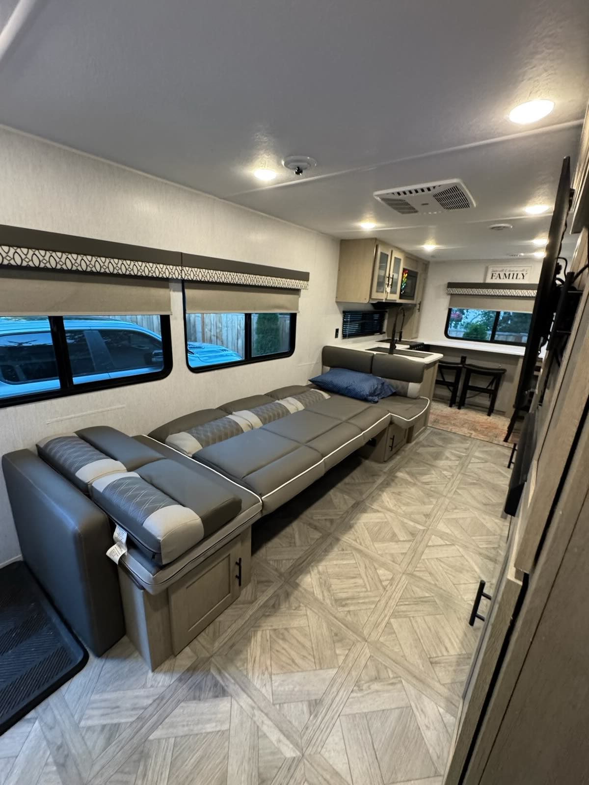 Modern RV rental interior shows a grey sofa that converts to a bed, a kitchen, and a dining area, offering versatile living space.. Forest River EVO 2920VB 2024
