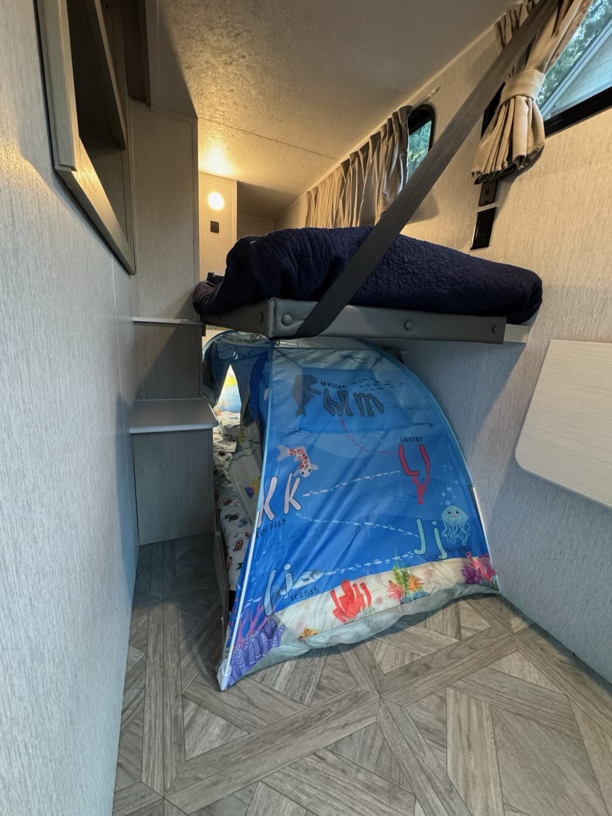 Cozy RV rental bunk beds: a top sleeping area and a fun, sea-themed pop-up tent bed for kids below.. Forest River EVO 2920VB 2024