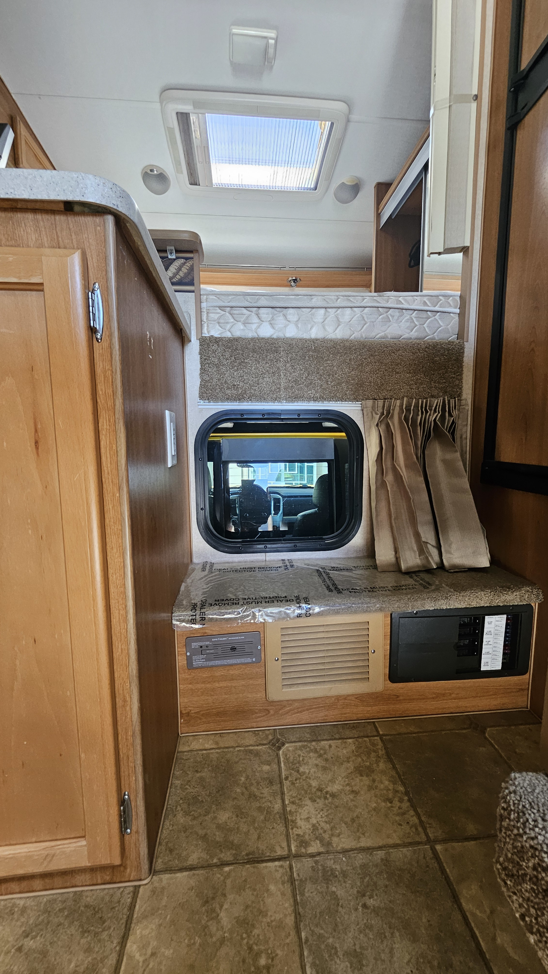 RV rental interior: bunk bed, window to the cab, and control panel with a CO detector. Ready to go!. Lance 861 2016