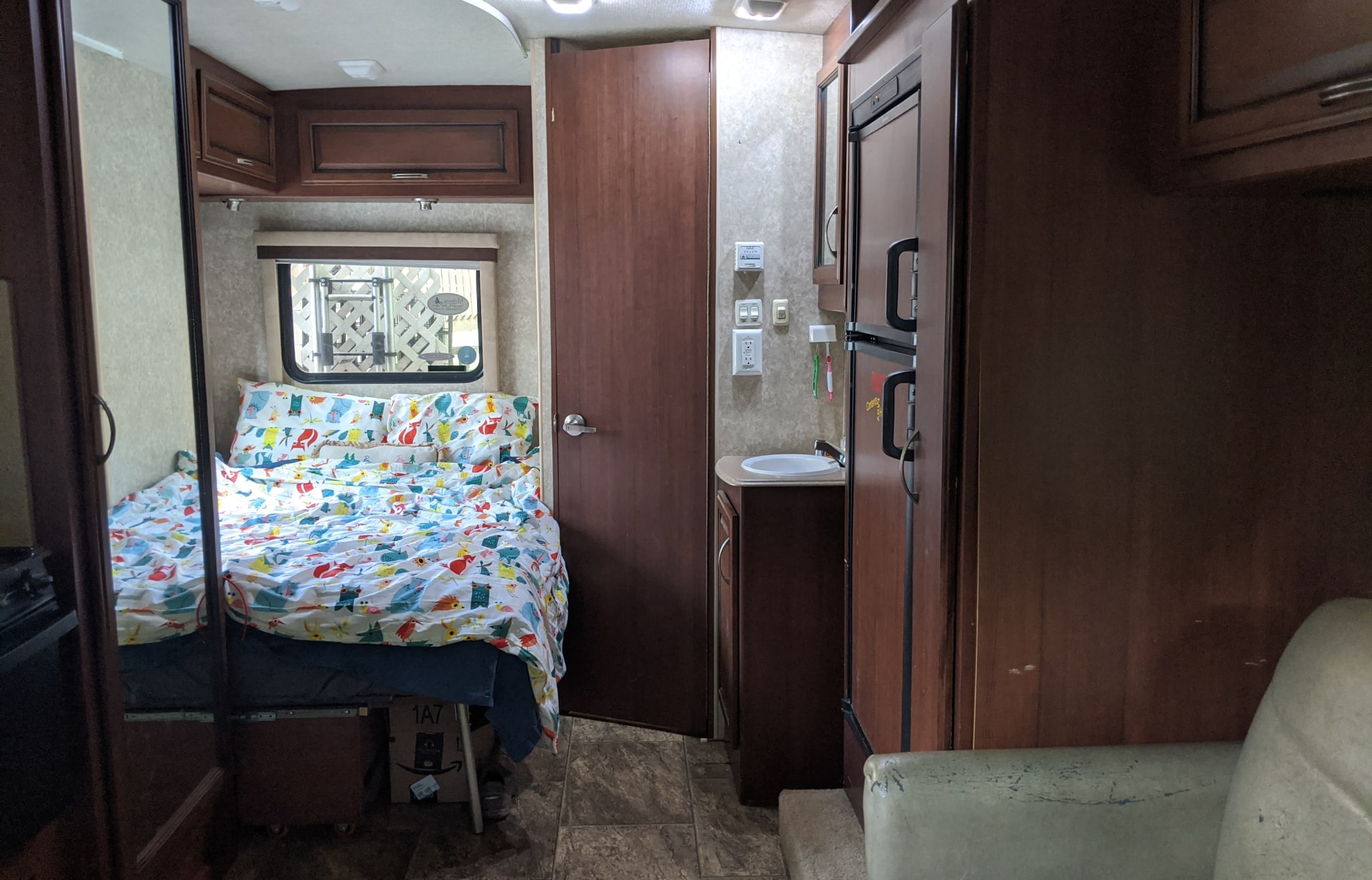Cozy RV rental interior featuring a colorful bed, compact sink, and refrigerator, ideal for your next road trip.. Tioga Ranger 2011