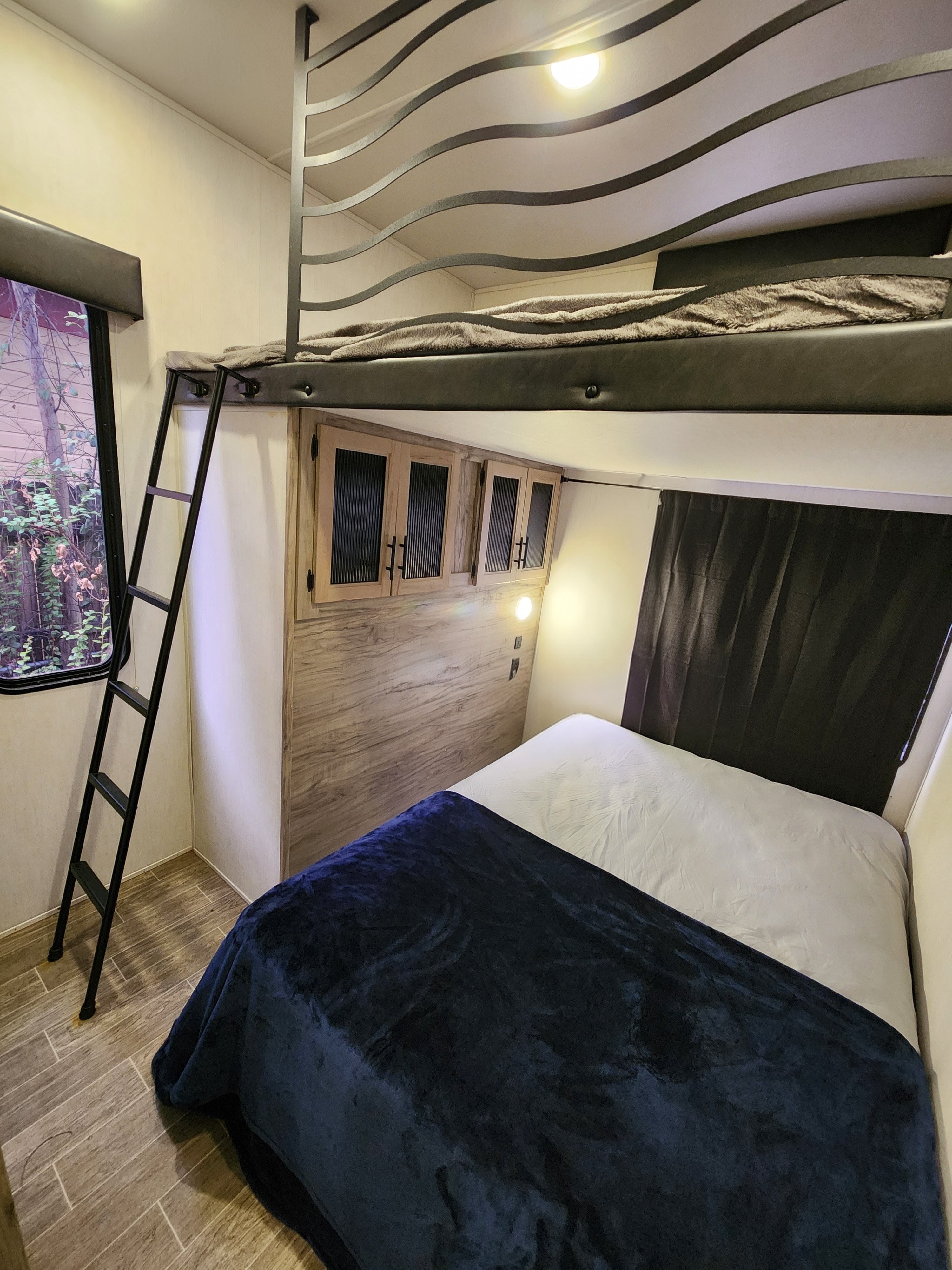 Cozy RV rental bedroom featuring lower and upper bunk beds, perfect for family adventures.. Forest River Cherokee Arctic Wolf 2022