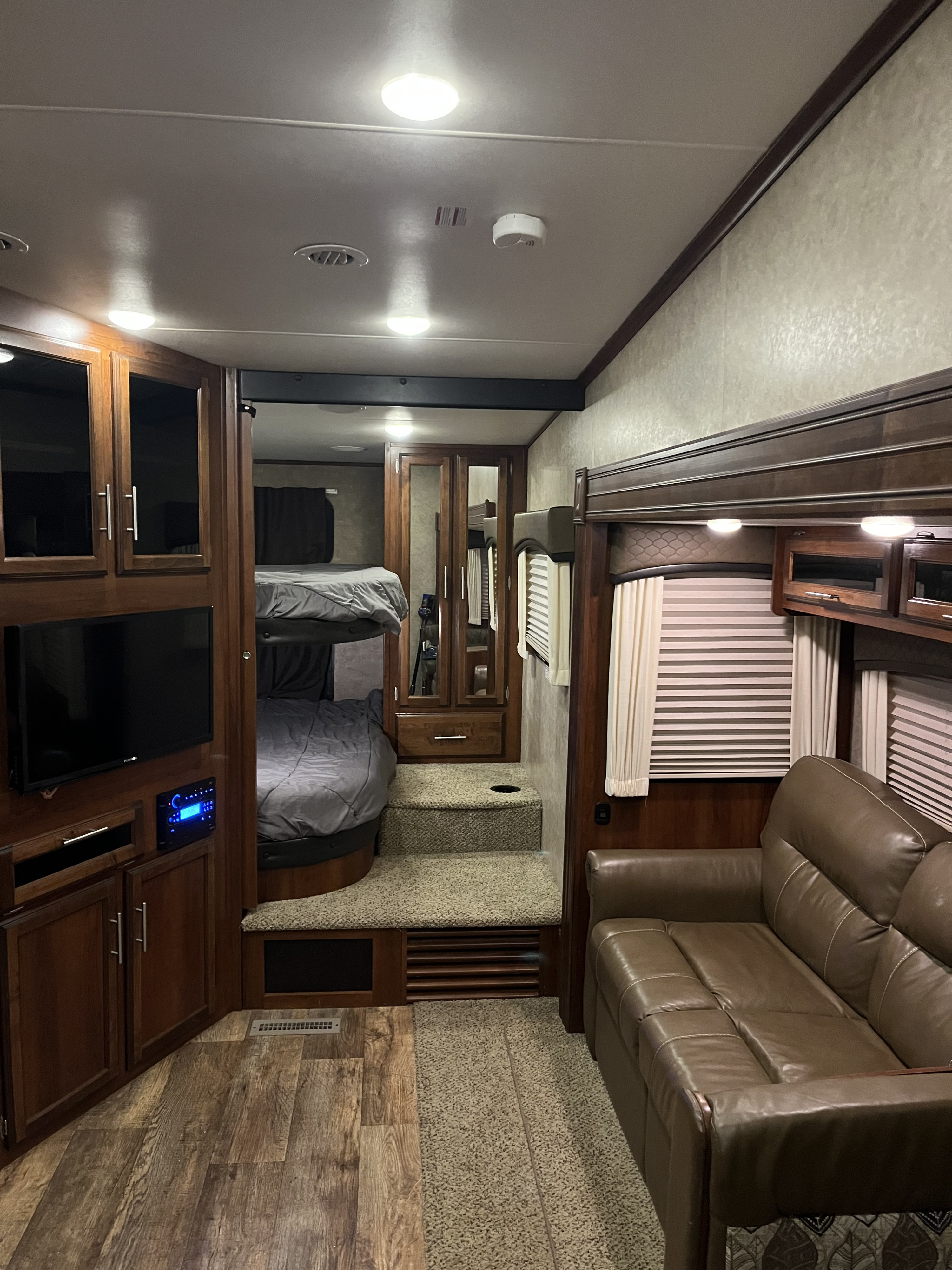 RV rental interior: inviting living area with leather sofa, entertainment system, plus cozy bunk beds. Great for family trips!. Jayco Eagle HT 2017