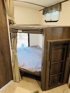 RV rental interior: cozy bunk beds with bedding and window, ready for a good night's sleep.. Keystone Passport 2021