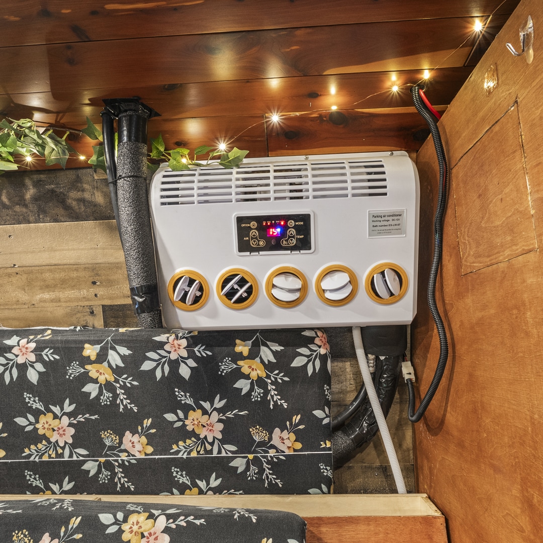 Cool comfort in your RV rental! Interior features a mounted AC unit, floral seating, string lights & wooden accents.. Ford Econoline 150 2007