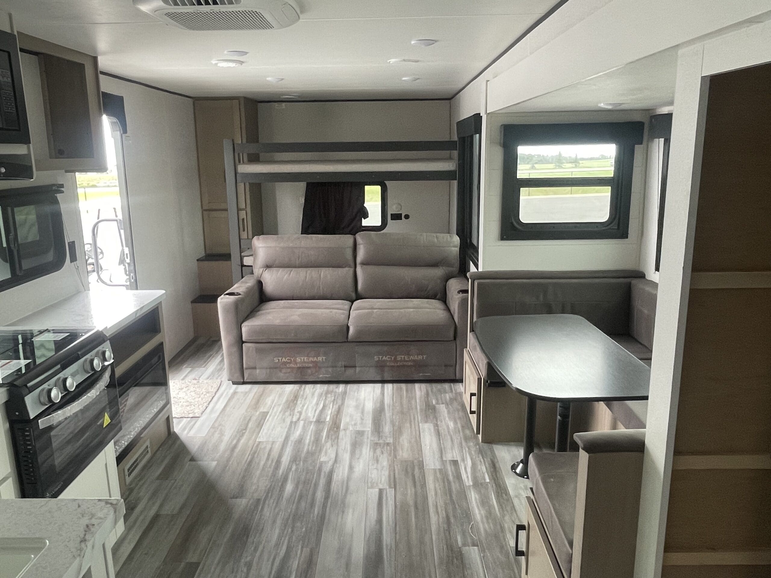 Spacious rv rental interior featuring a cozy living space, kitchen, dinette, and bunk beds. Perfect for camping adventures!. Jayco SLX 287BHSW 2026