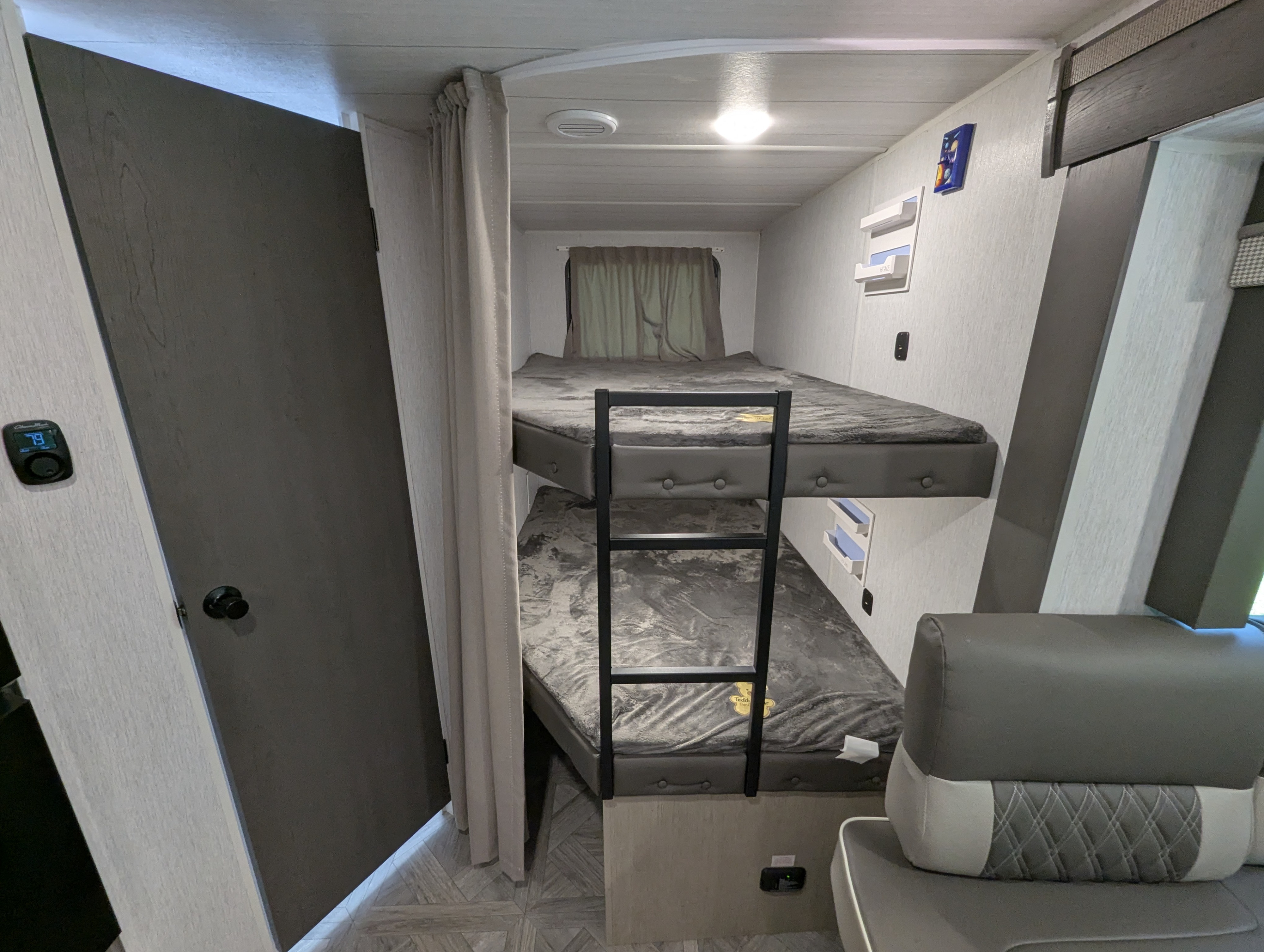 RV rental bunk beds feature a privacy curtain & ladder for comfortable sleeping. Compact interior is ideal for travel.. Forest River Wildwood X-Lite 2024