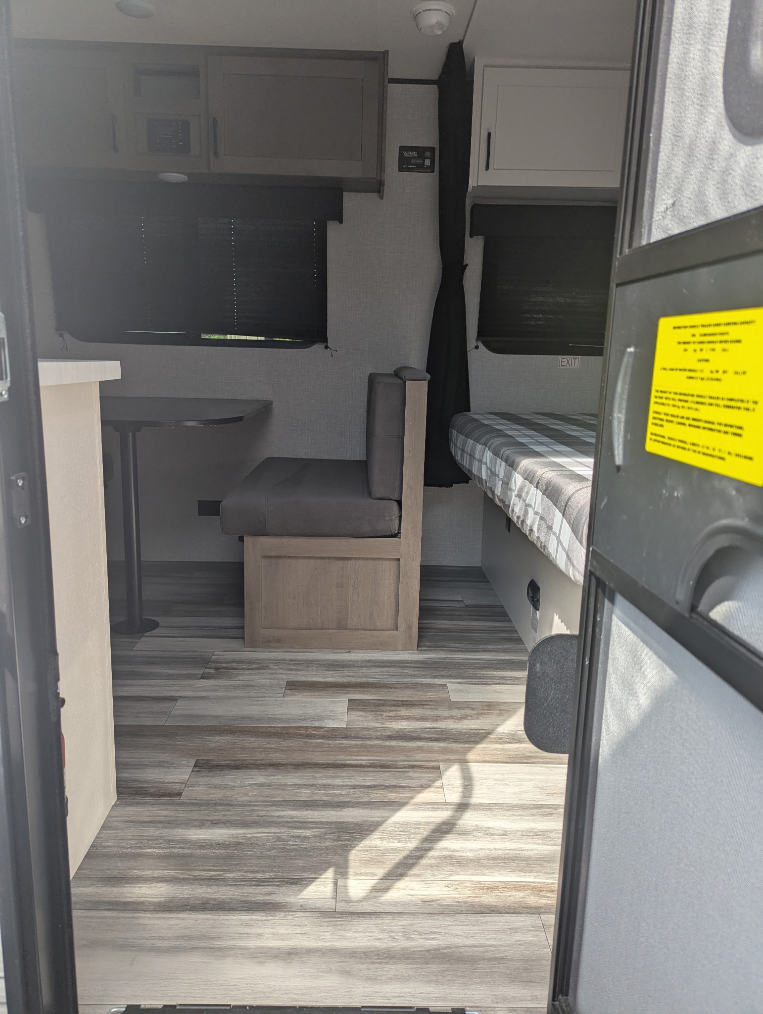 View inside a modern **rv rental**, featuring a dinette seating area, overhead storage, and a built-in bed.. Jayco Jay Flight SLX 2025