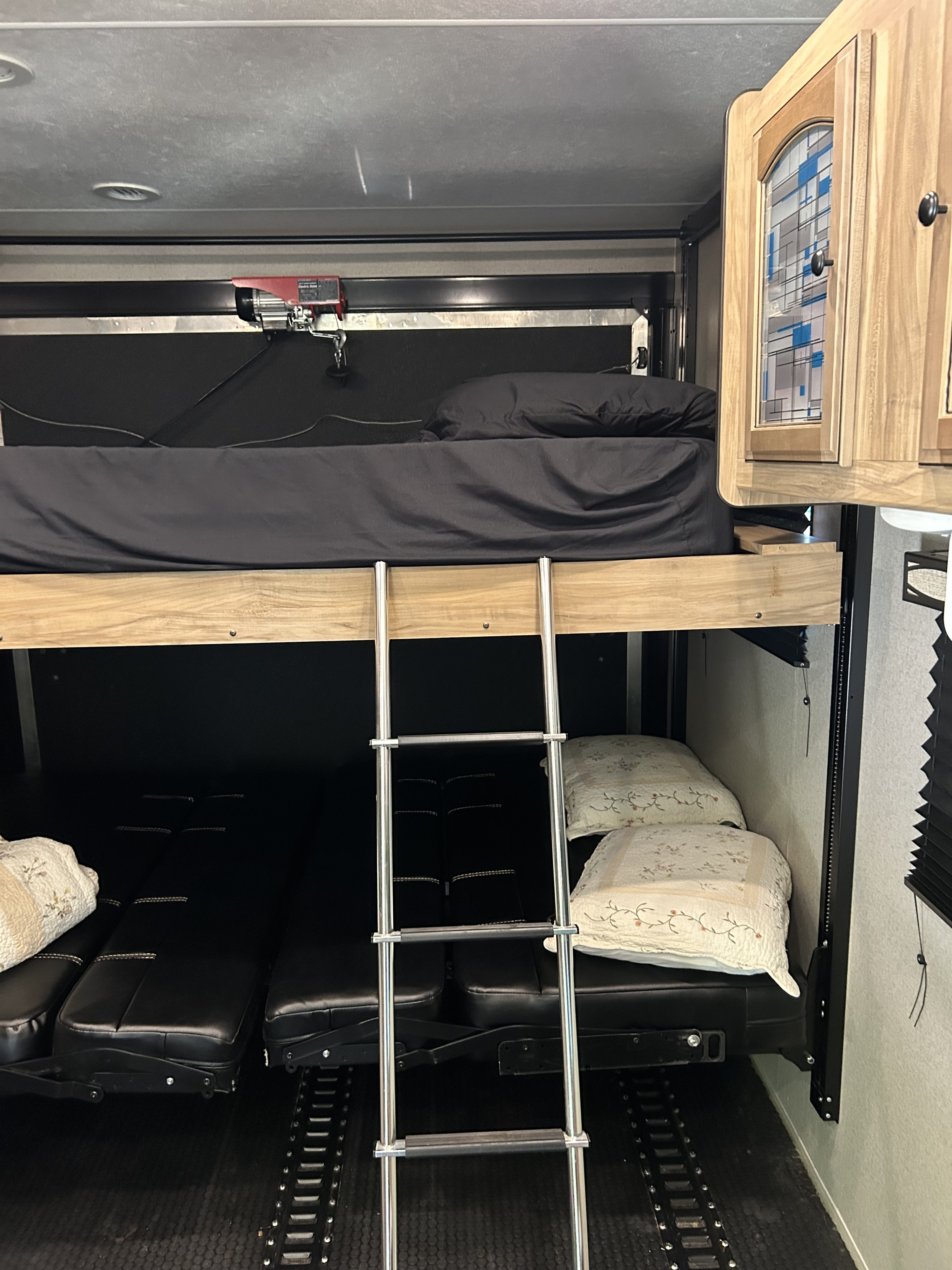 This RV rental offers multi-level sleeping with an upper bunk bed, ladder, and adaptable lower seating/beds with floor tracks.. Coachmen Freedom Express 2018