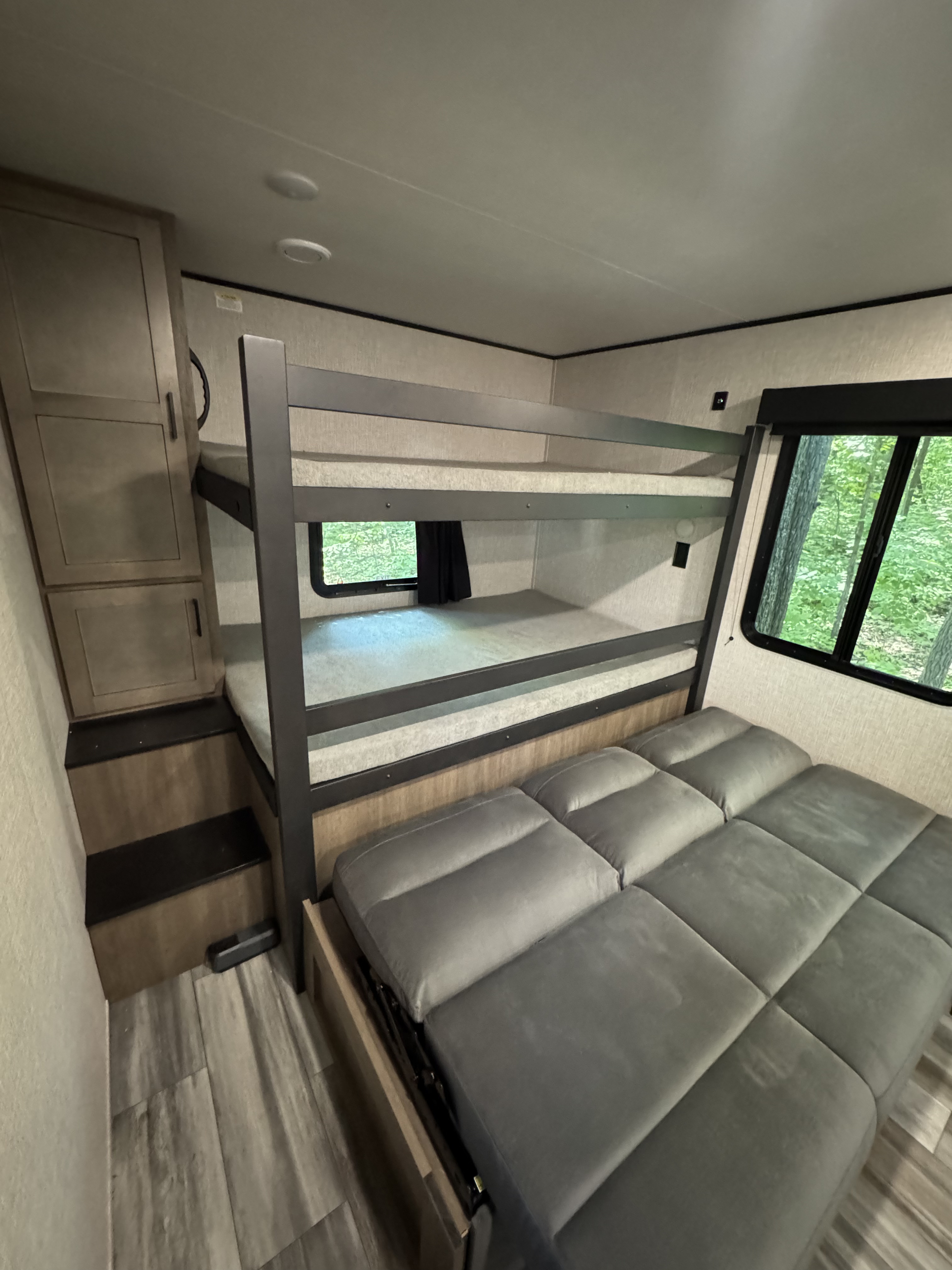 Cozy RV rental interior with bunk beds, a sofa, and storage. Ideal for family adventures in a travel trailer.. Jayco Jay Flight SLX 2025