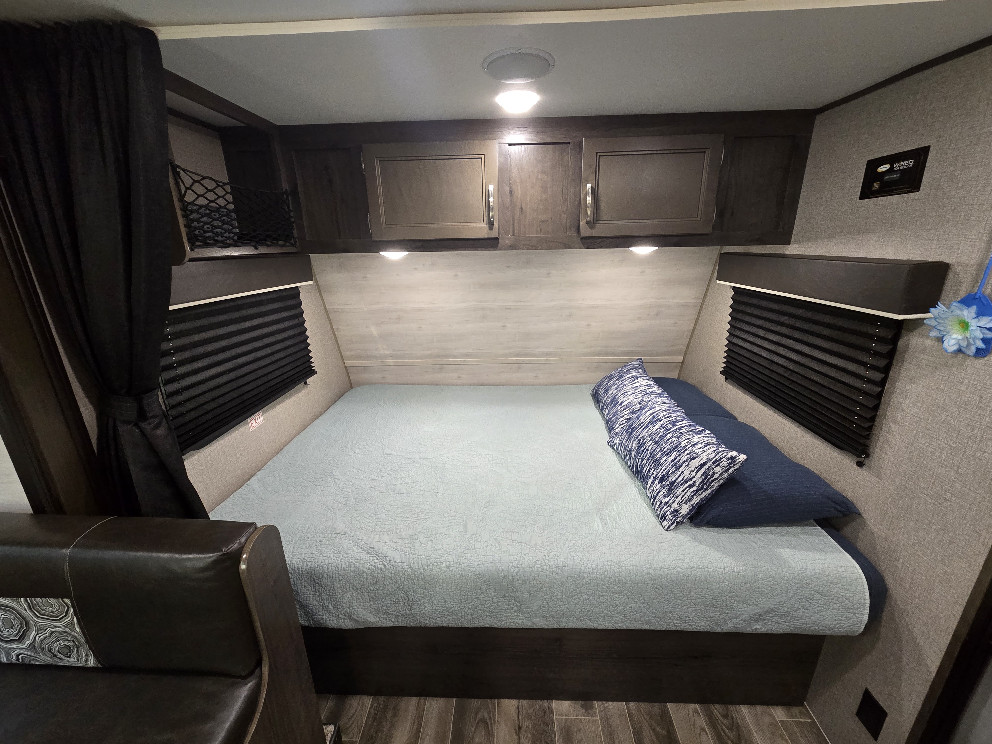 Comfortable RV rental bedroom with a large bed, overhead storage, and window blinds, designed for cozy travel stays.. Jayco Jay Flight SLX 2021