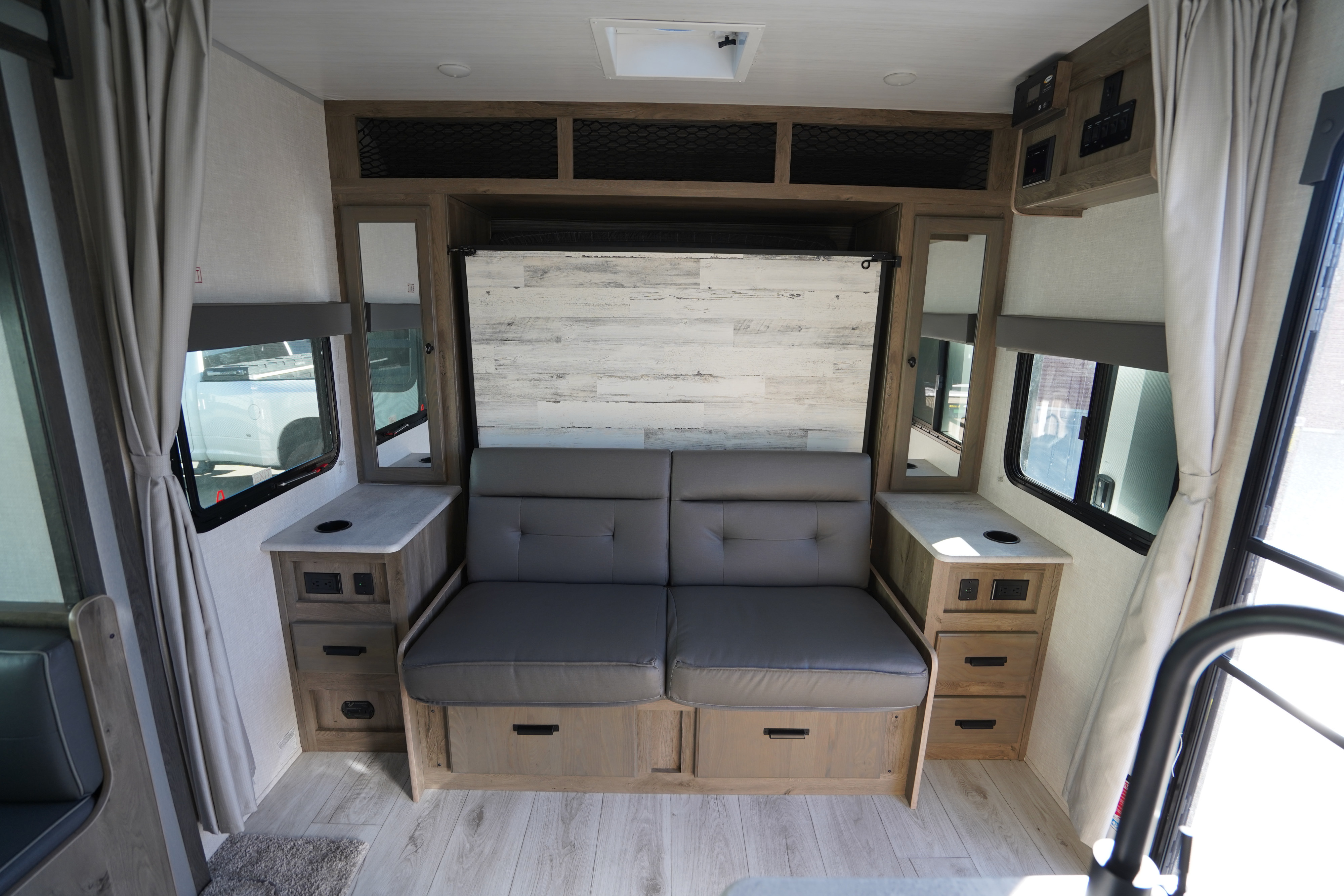 RV rental interior: living area with a versatile pull-out sofa, integrated storage, window views, and overhead compartments.. Forest River Surveyor Legend 2022