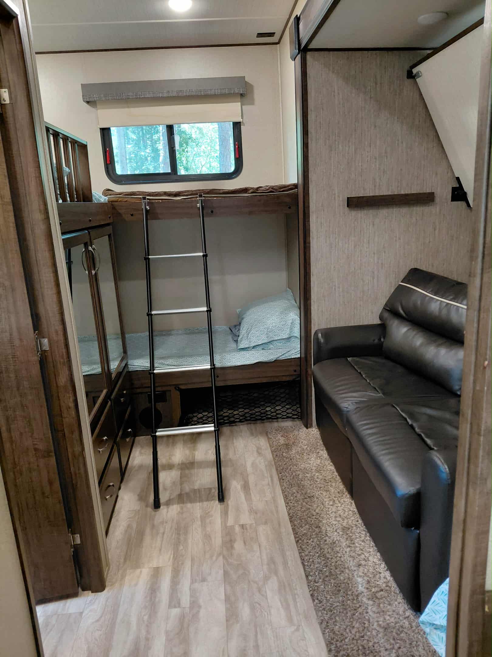 Inside this RV rental: Bunk beds, a comfy sofa, and smart storage maximize space for a great travel experience.. Grand Design Solitude 2019