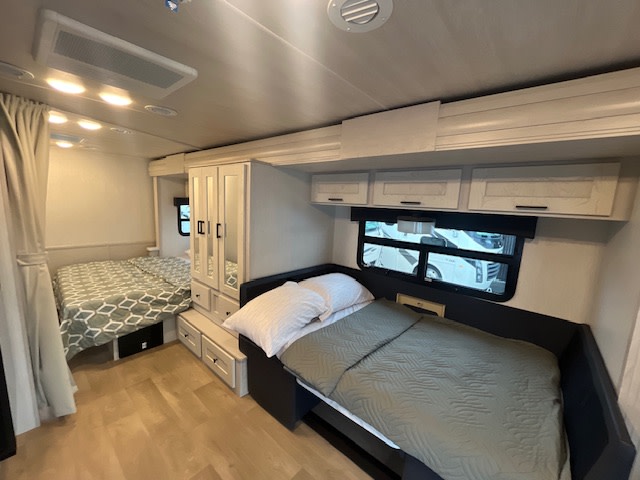 RV rental interior featuring two comfortable sleeping areas with beds, central wardrobe, and overhead cabinets for storage.. Nexus Viper 2026