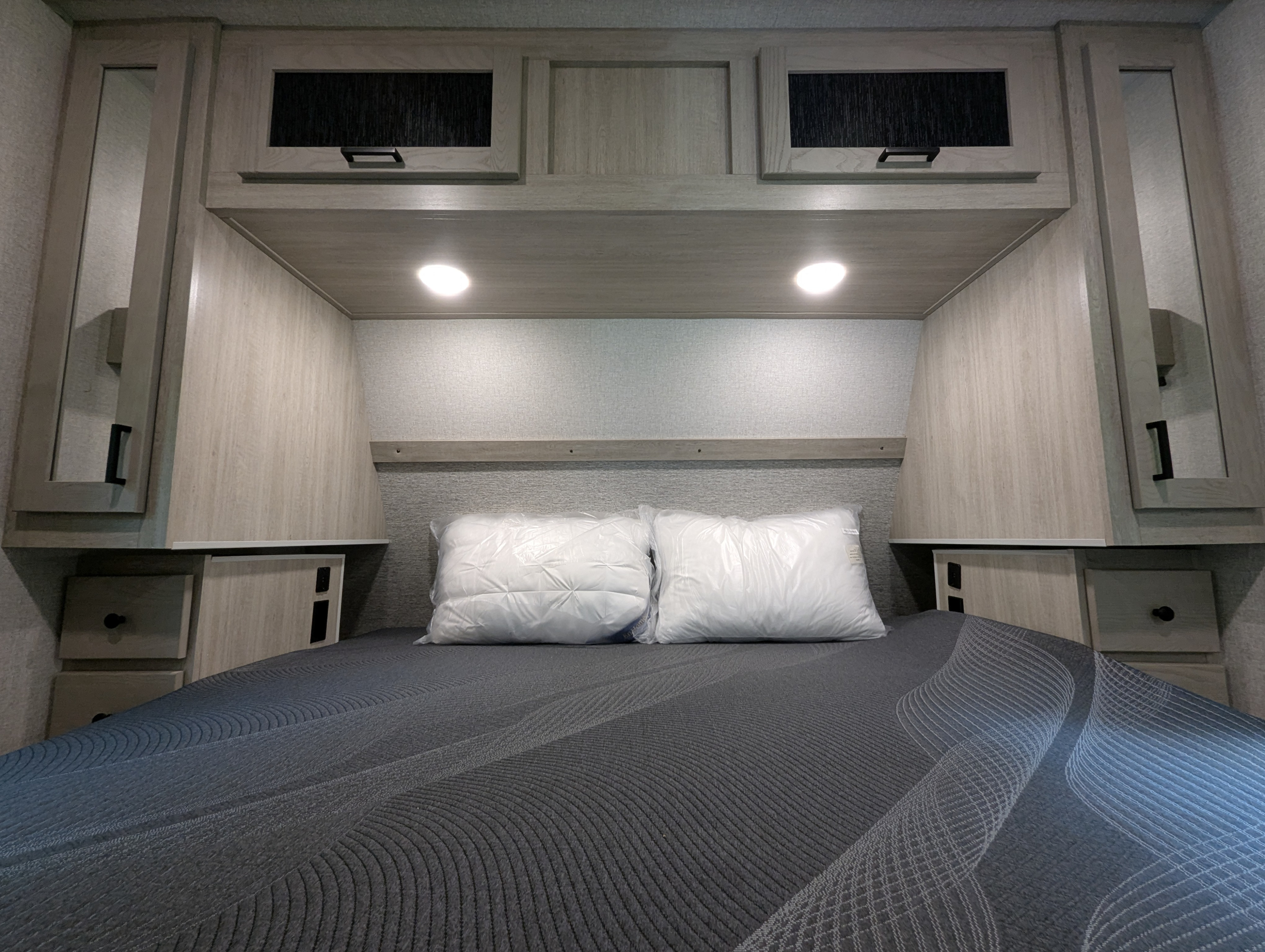 RV rental bedroom with overhead cabinets, side storage, and a new mattress.. Forest River INC. Alta 2022