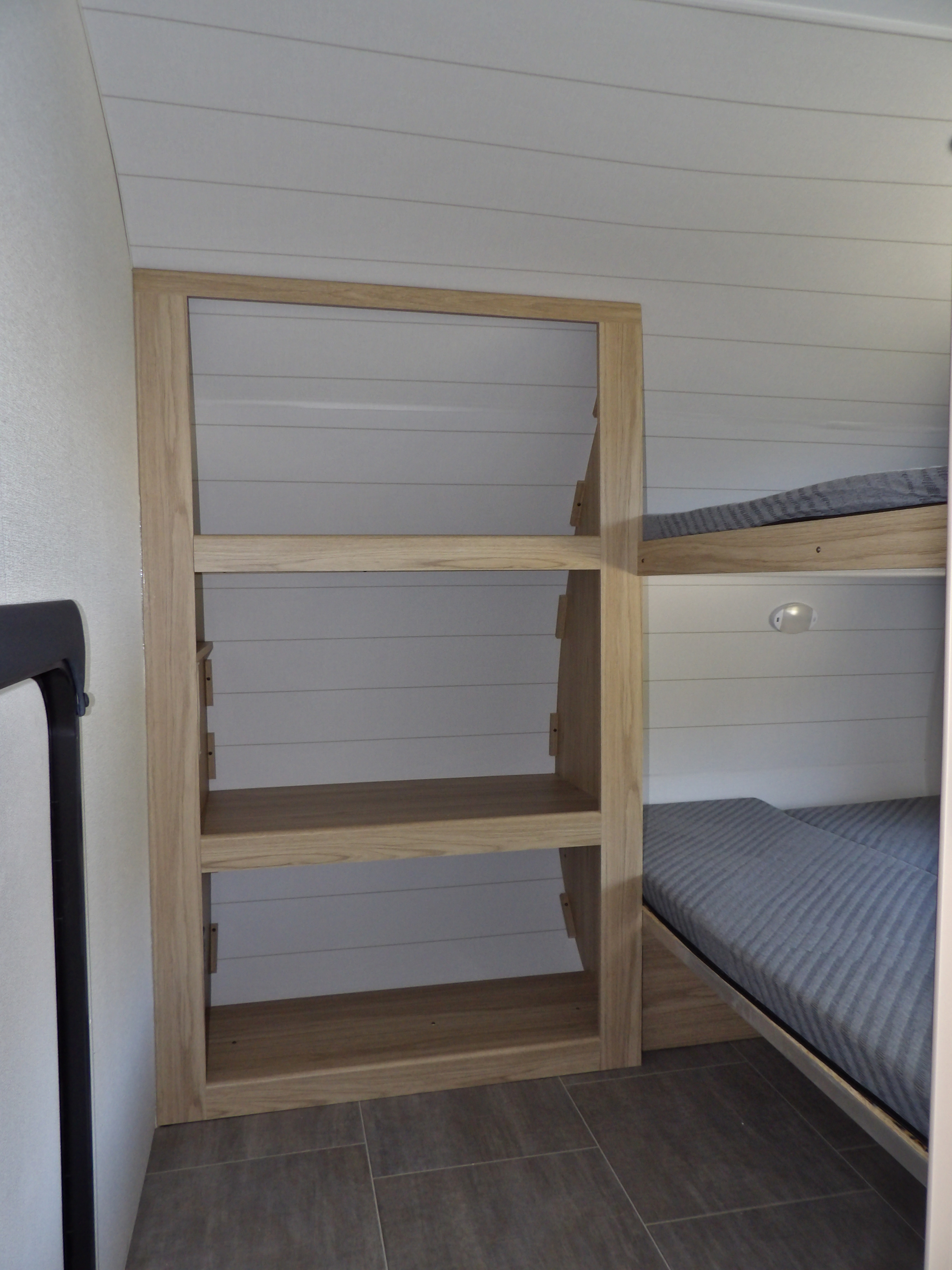 RV rental interior with bunk beds, shiplap walls, and built-in storage. Compact and functional design for travel.. Other Other 2025