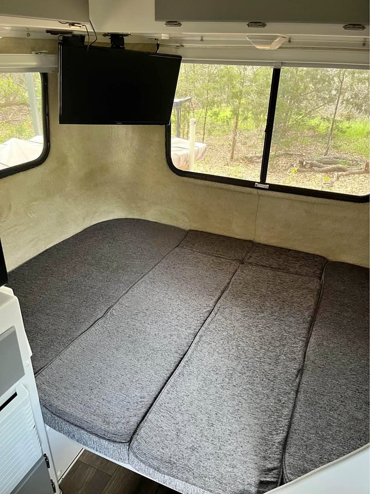 RV rental: Interior shot of a comfortable bed with grey cushions, mounted TV, and large windows with a nature view.. Casita Casita Trailer 2020