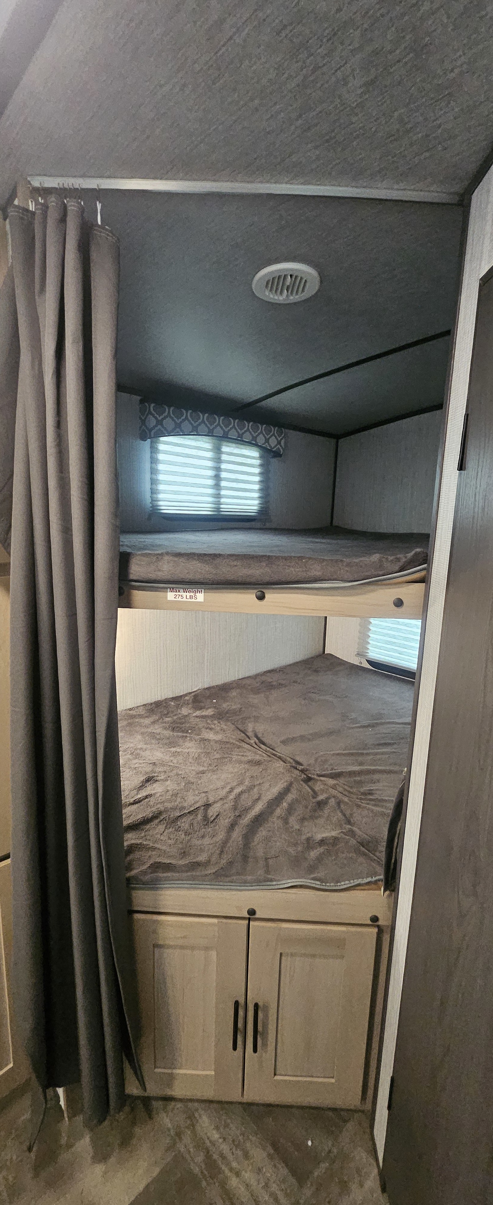 RV rental interior featuring cozy bunk beds (275 lbs max), windows, curtain, & lower cabinets. Perfect camper sleeping.. Cruiser RV Radiance Ultra Lite 2020
