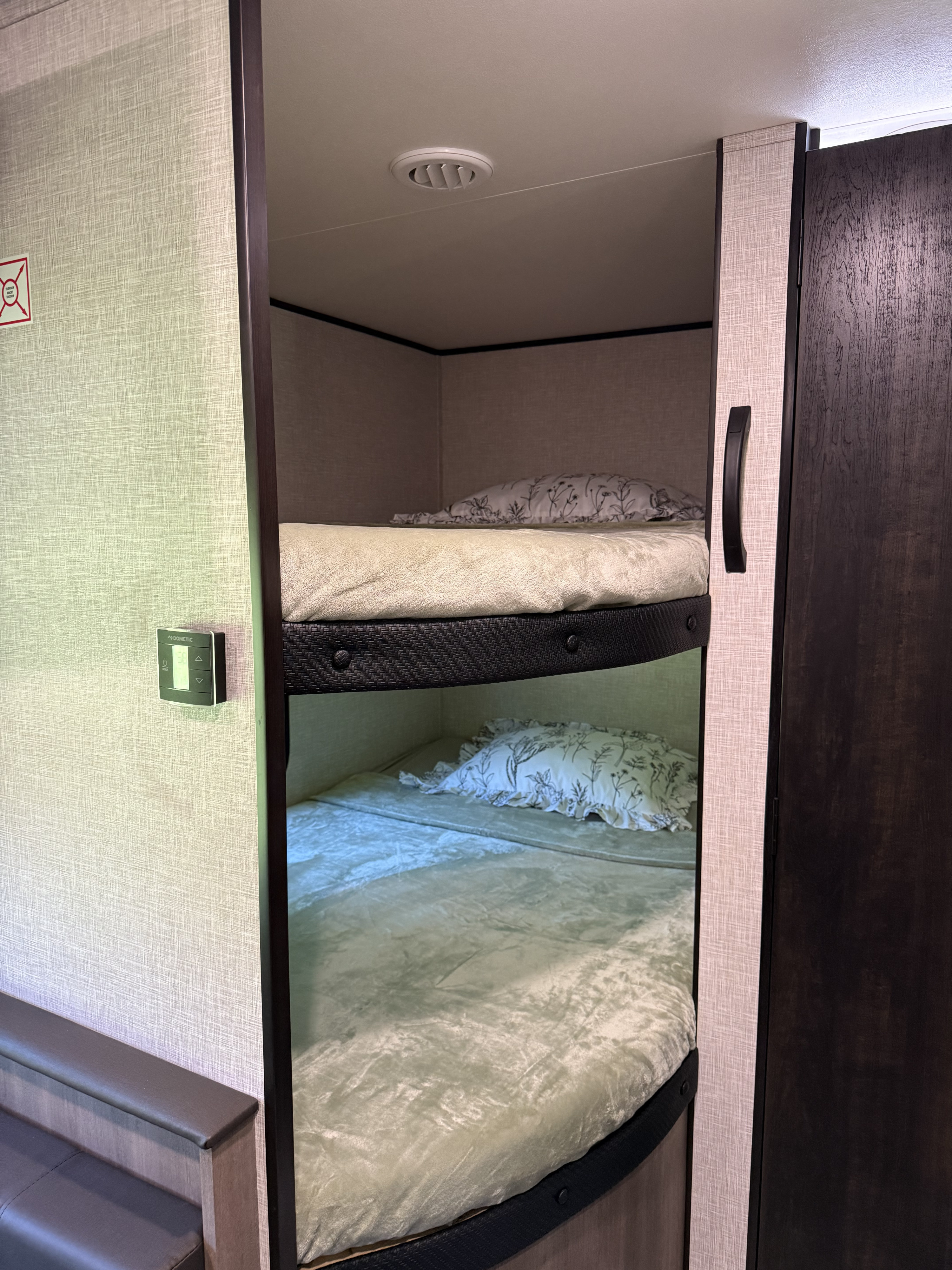 RV rental: Interior shot showing cozy bunk beds, complete with bedding and a Dometic thermostat on the wall.. Jayco Jay Flight SLX 2024
