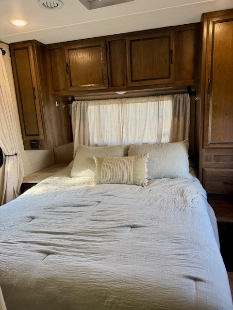 Cozy RV rental bedroom with a comfy bed, overhead storage, and window for a restful stay.. Forest River Coachmen Freelander 2018