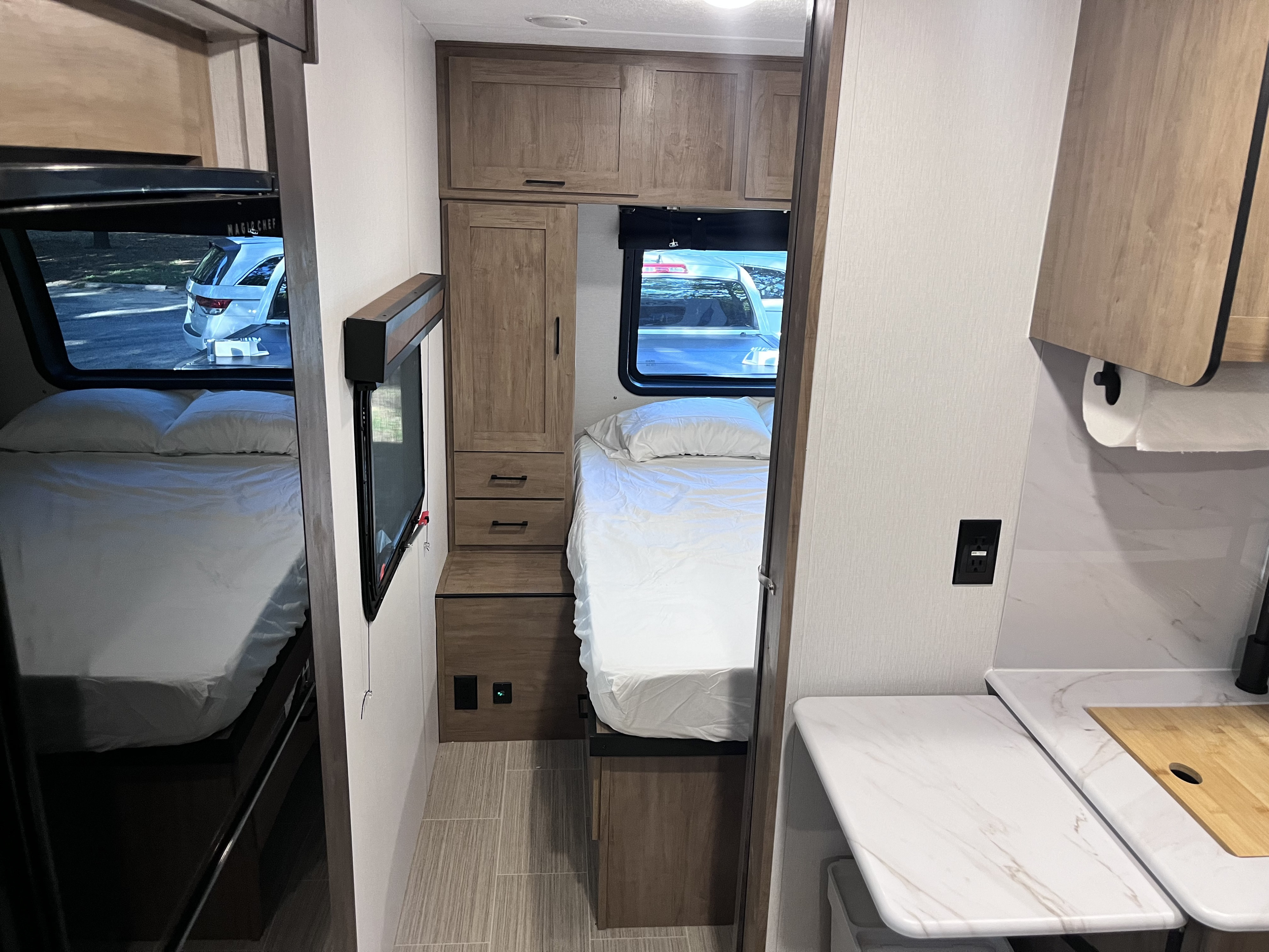 Cozy and modern RV rental interior featuring a bedroom area with bunk beds and a small kitchenette.. Forest River Coachmen Freedom Express Ultra Lite 2024