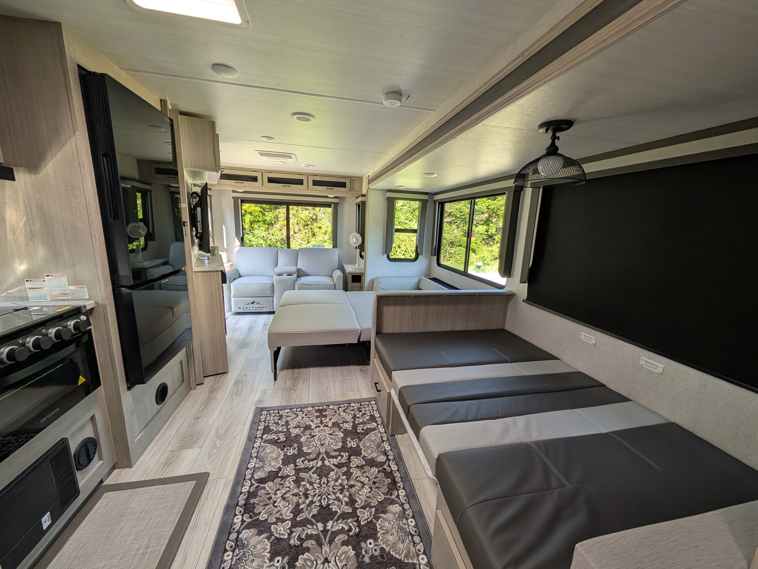 Spacious RV rental interior featuring a modern kitchen, comfortable living area with recliner sofa, and a convertible dinette.. Forest River Alta 2850KRL 2025