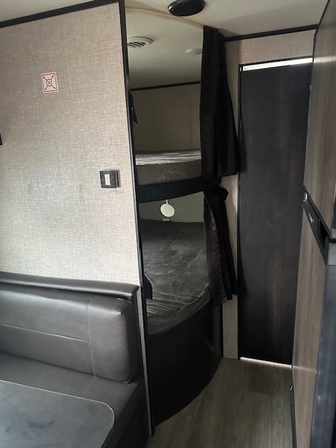 RV rental interior: cozy bunk beds, dinette seating, and compact living space. Perfect for family adventures.. Jayco Jay Flight SLX 2022