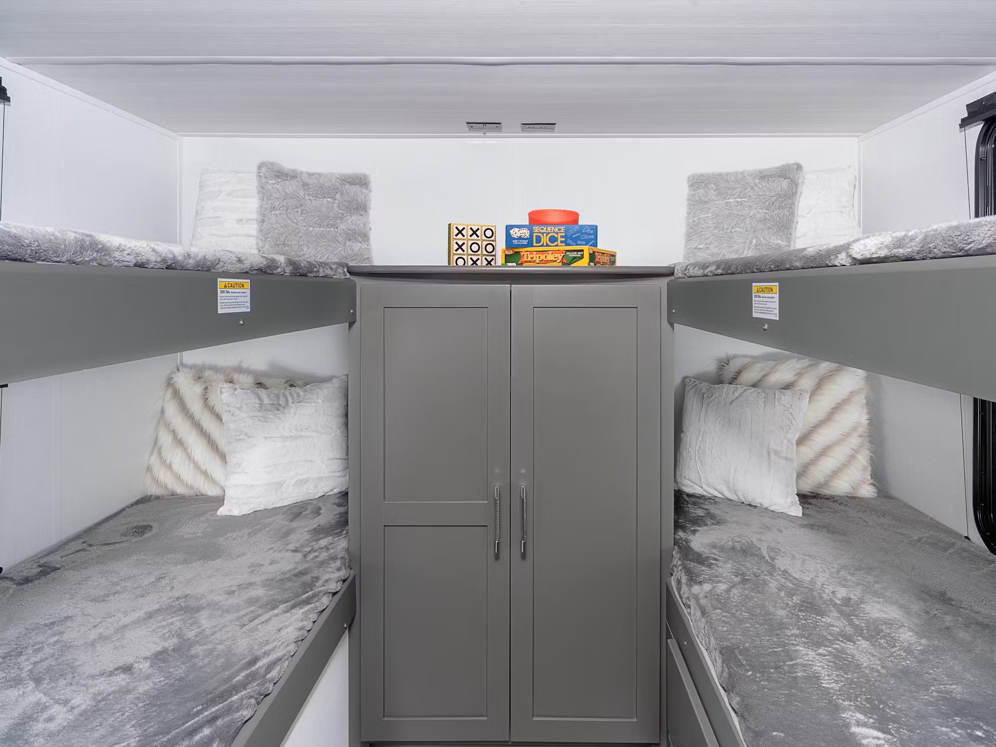 This RV rental offers a compact, fun sleeping area with four bunk beds, soft gray bedding, games, and central storage.. Keystone 2840 QBWE 2025