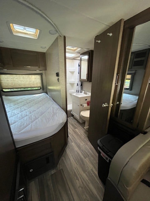 Compact RV rental interior: a practical layout with a bed, vanity, toilet, and shower, maximizing space for travel.. Thor Four Winds 2020