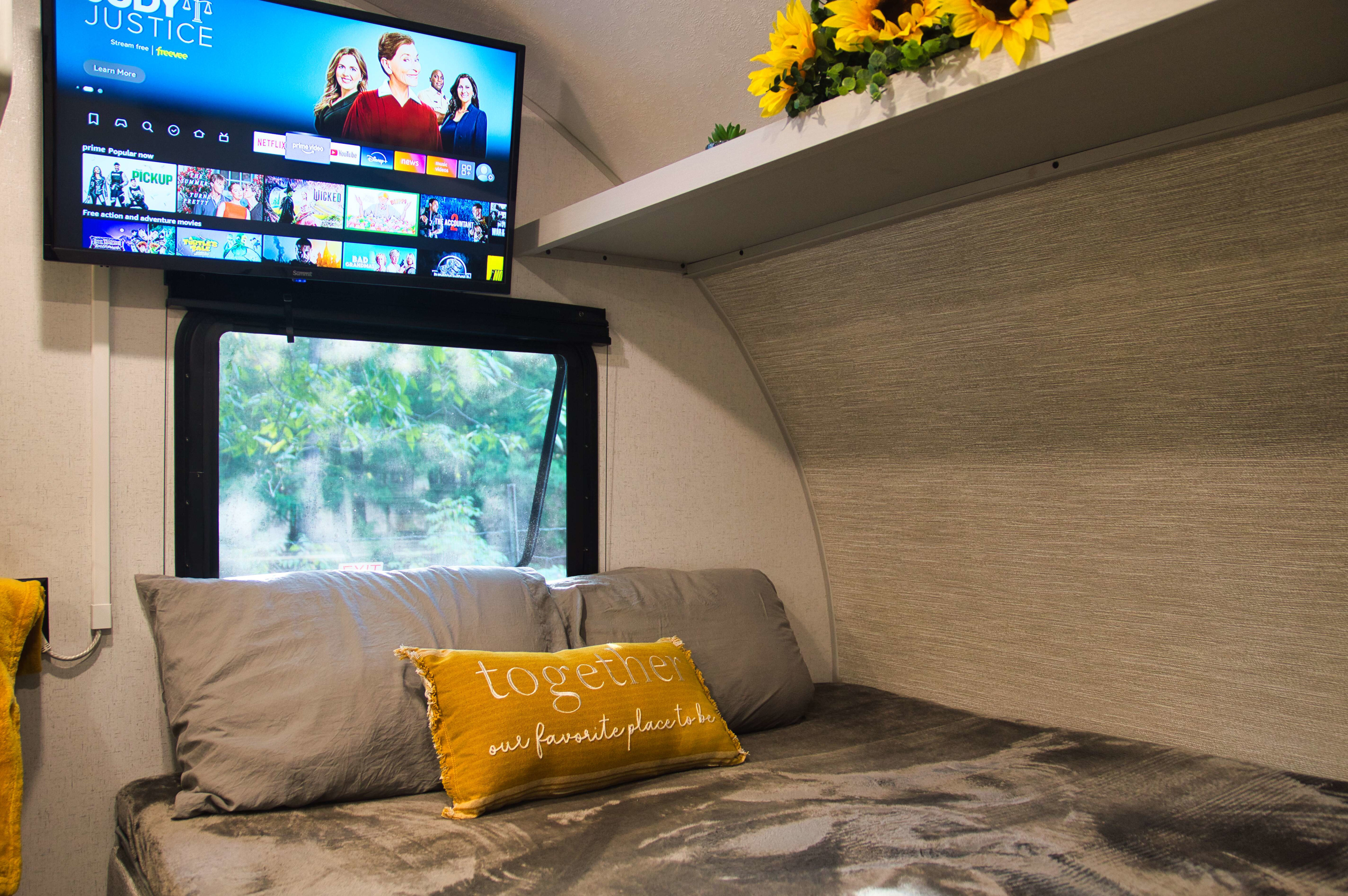 This RV rental bedroom offers a cozy bed, TV with streaming services, and a window for nature views.. Forest river Salem FSX 2023