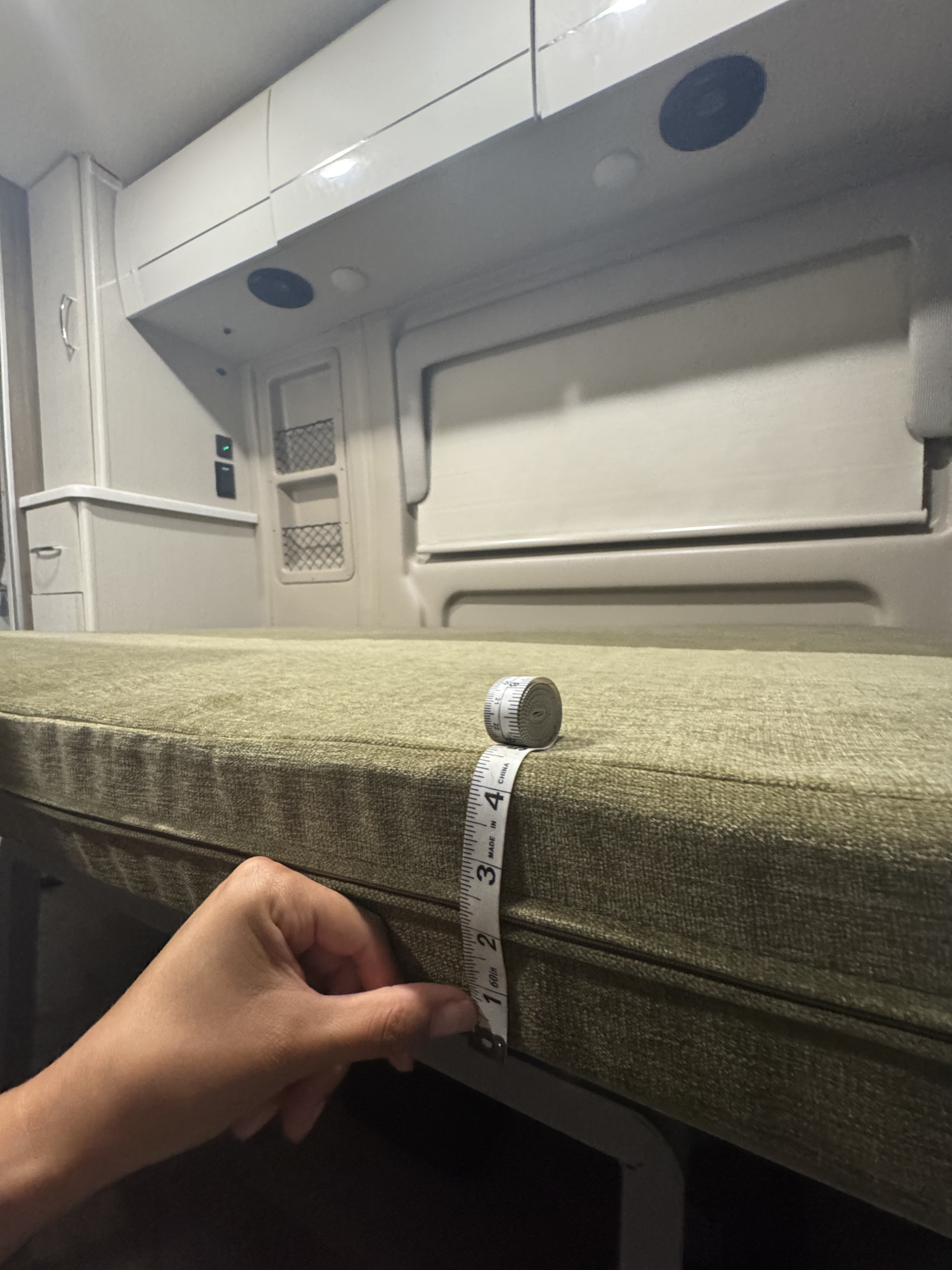 Measuring an RV rental cushion (approx. 3 inches thick) to assess bed comfort and fit in the camper's interior.. Thor Rize 2023