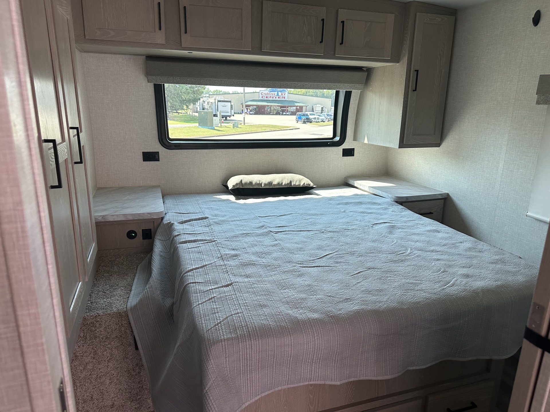 Cozy RV rental bedroom featuring a bed, storage, and window overlooking Crabtree RV Center. Ideal for your next journey.. Forest River Flagstaff Micro Lite 2023