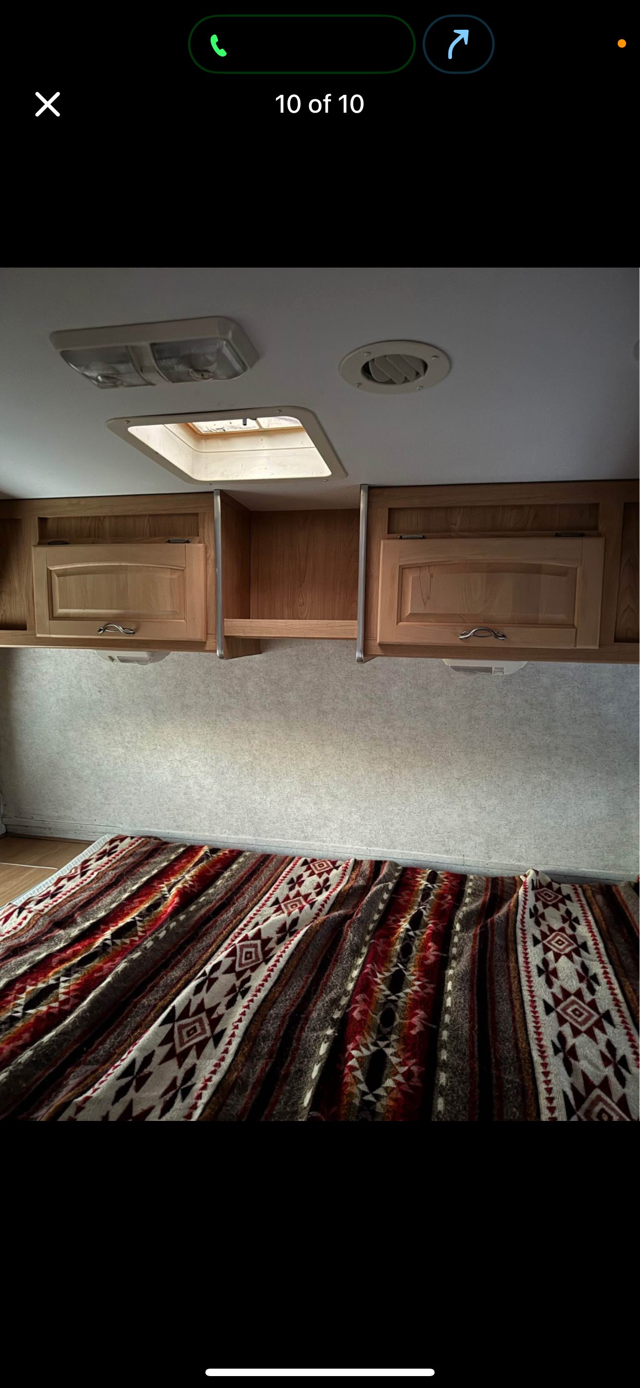 RV rental interior: Cozy bedroom with overhead cabinets, skylight, and a vibrant patterned blanket on the bed.. Thor Motor Coach Vortex 2005
