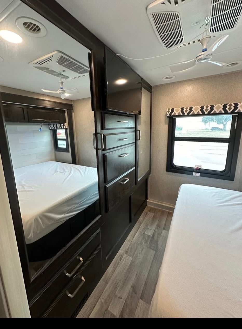 RV rental: modern bedroom with main bed, second sleeping area, TV, mirror, and ample storage for your journey.. Jayco Greyhawk 2021