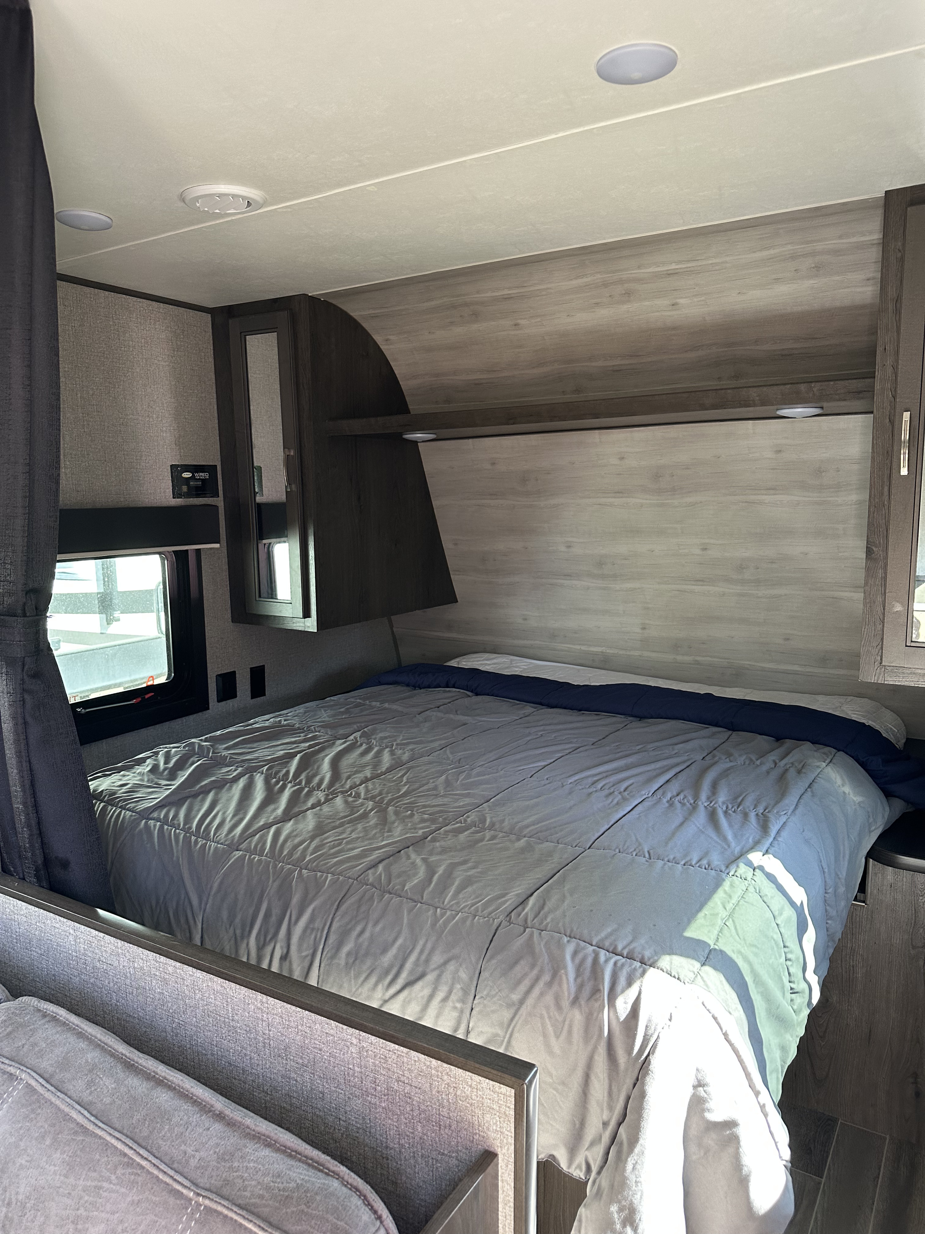 Cozy rv rental bedroom with a comfy bed, overhead storage, and a window providing natural light.. Jayco Jay Flight SLX 2021