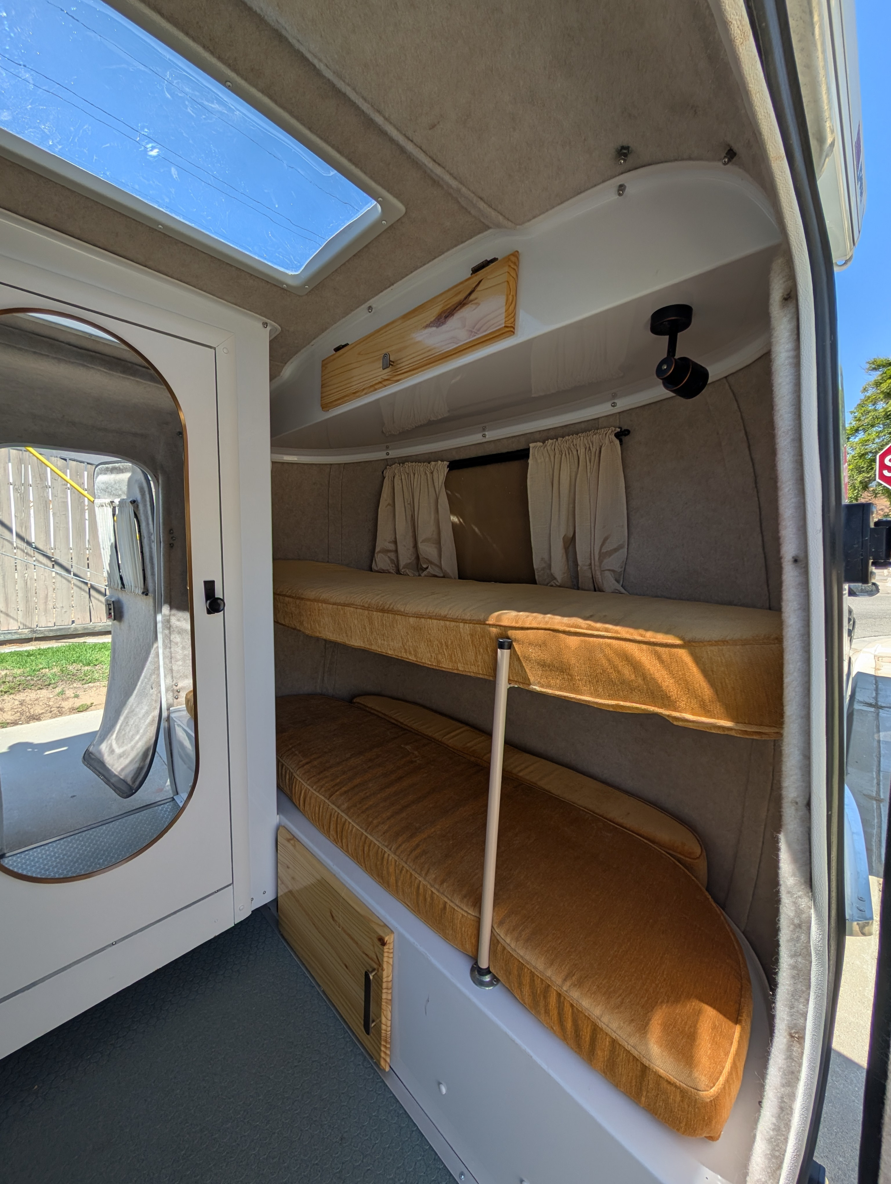 RV rental camper interior featuring cozy bunk beds, a skylight, and compact design, perfect for travelers.. Scamp Scamp Trailer 2020