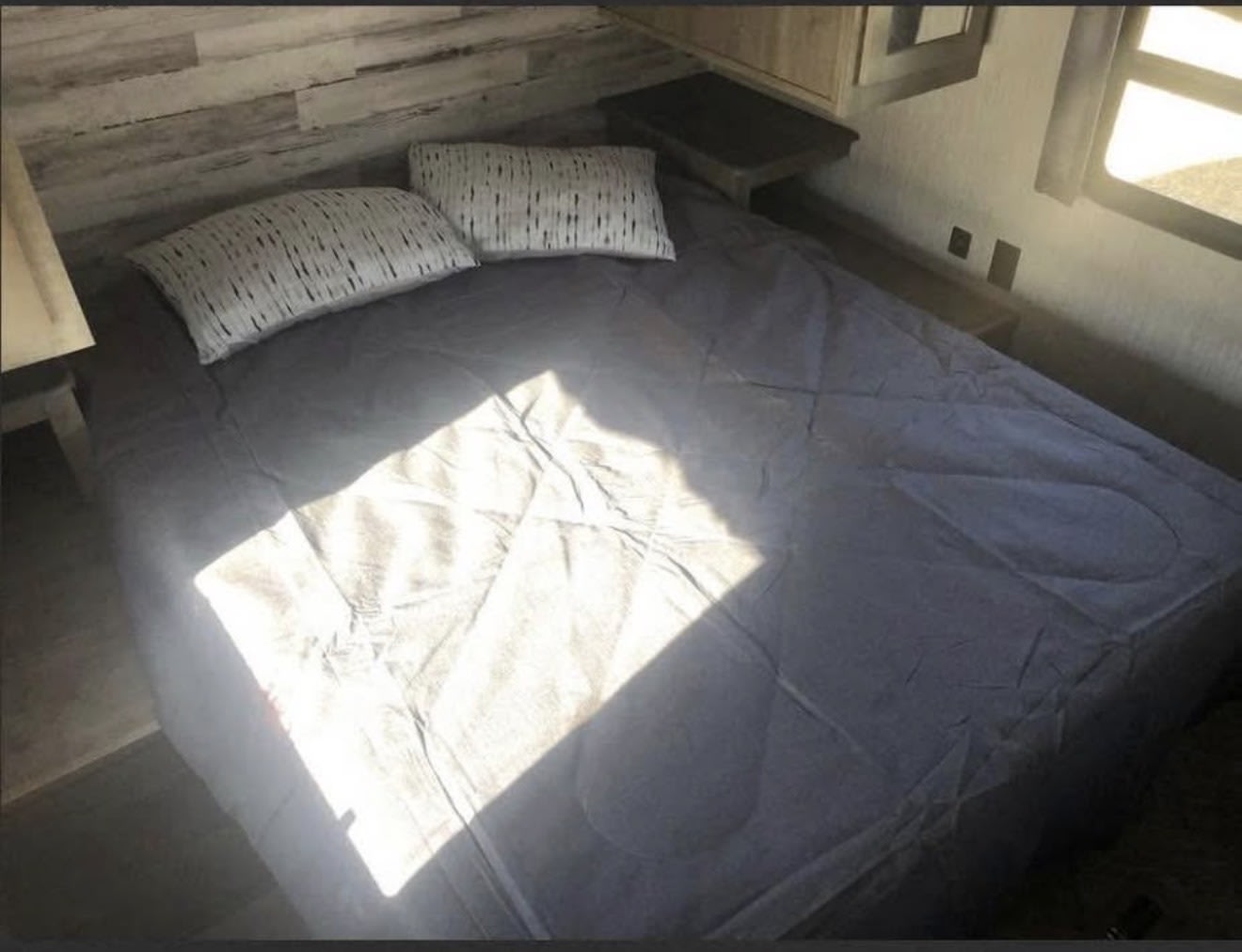 Cozy RV rental bedroom with a comfortable bed, pillows, and natural light. Ideal for a relaxing travel experience.. Forest River Palomino Puma 2022