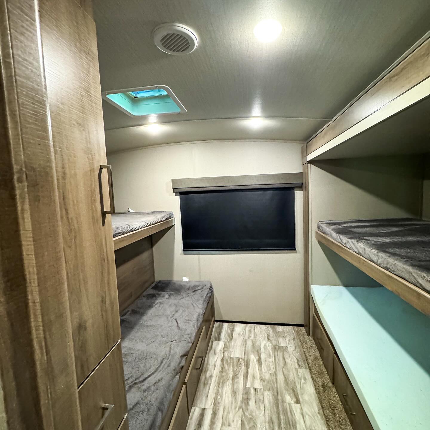 This RV rental bunk room shows four beds, a skylight, and window. Ideal for families and groups on a road trip.. Grand Design Imagine 2022