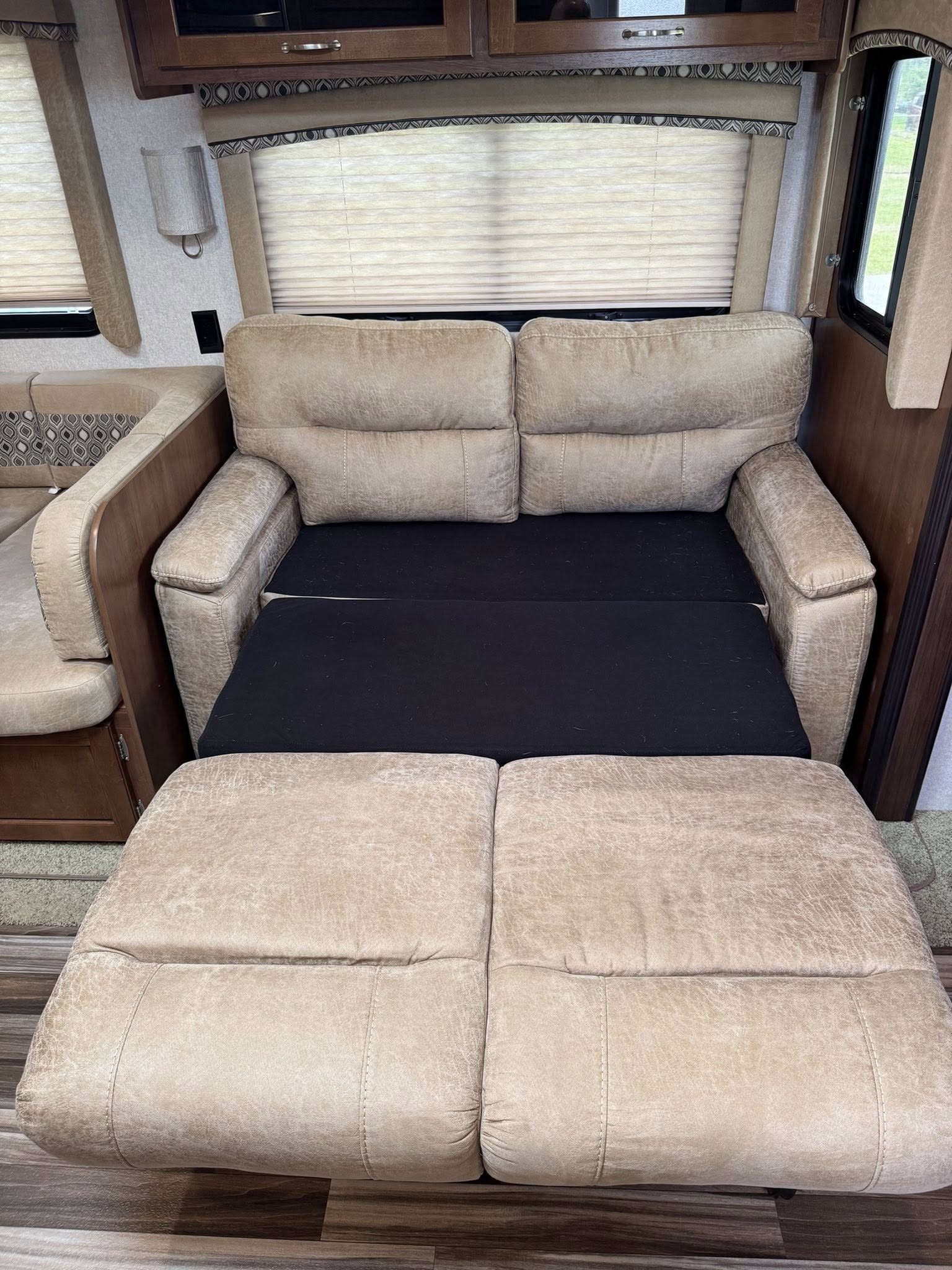 RV rental interior: Light beige pull-out sofa bed with black mattress fully extended, providing comfortable sleeping.. Jayco Jay Flight 2017