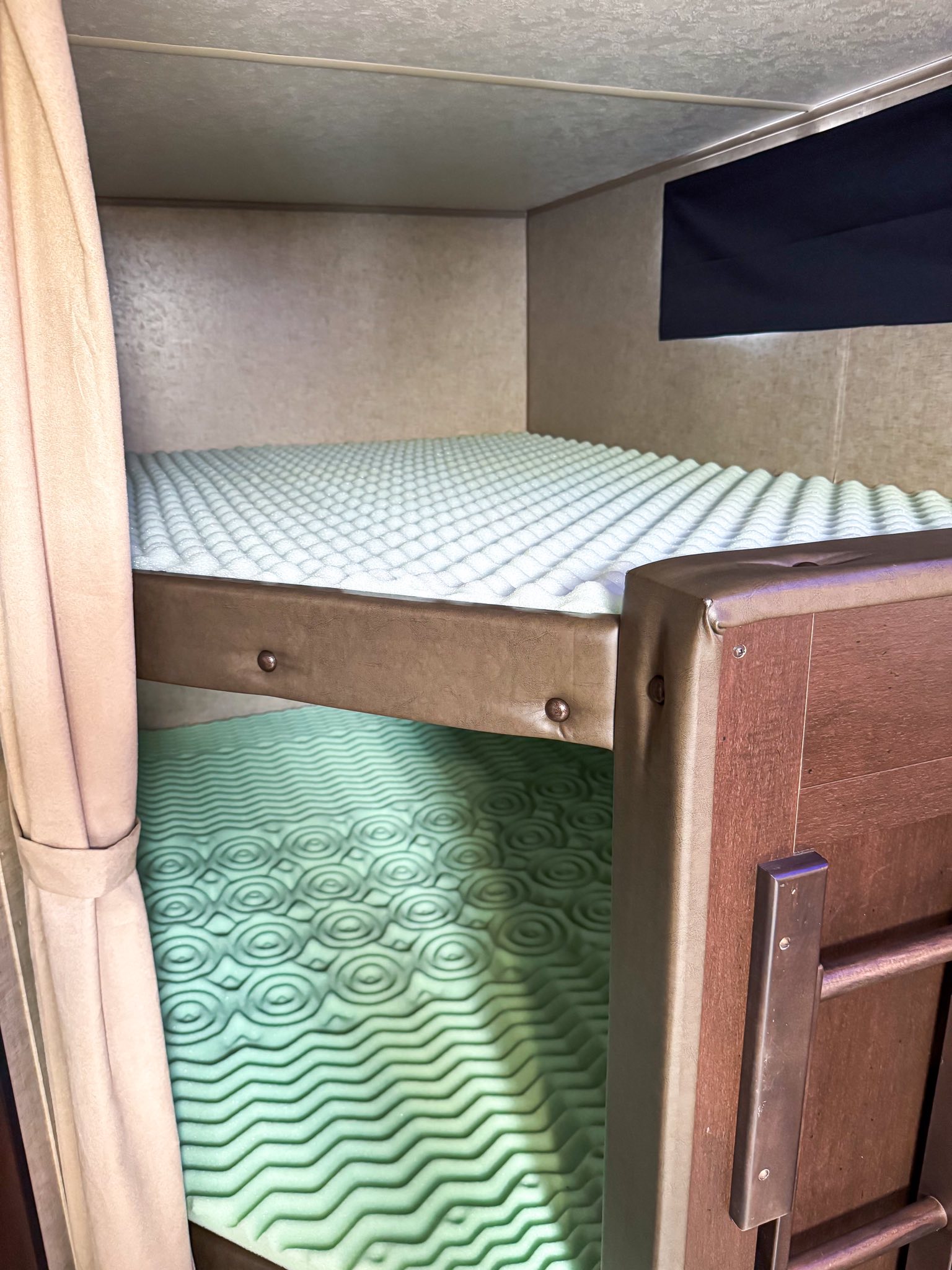 RV rental bunk beds feature soft foam mattress toppers; light blue egg-crate on top, green patterned on bottom.. Forest River Cherokee Grey Wolf 2017