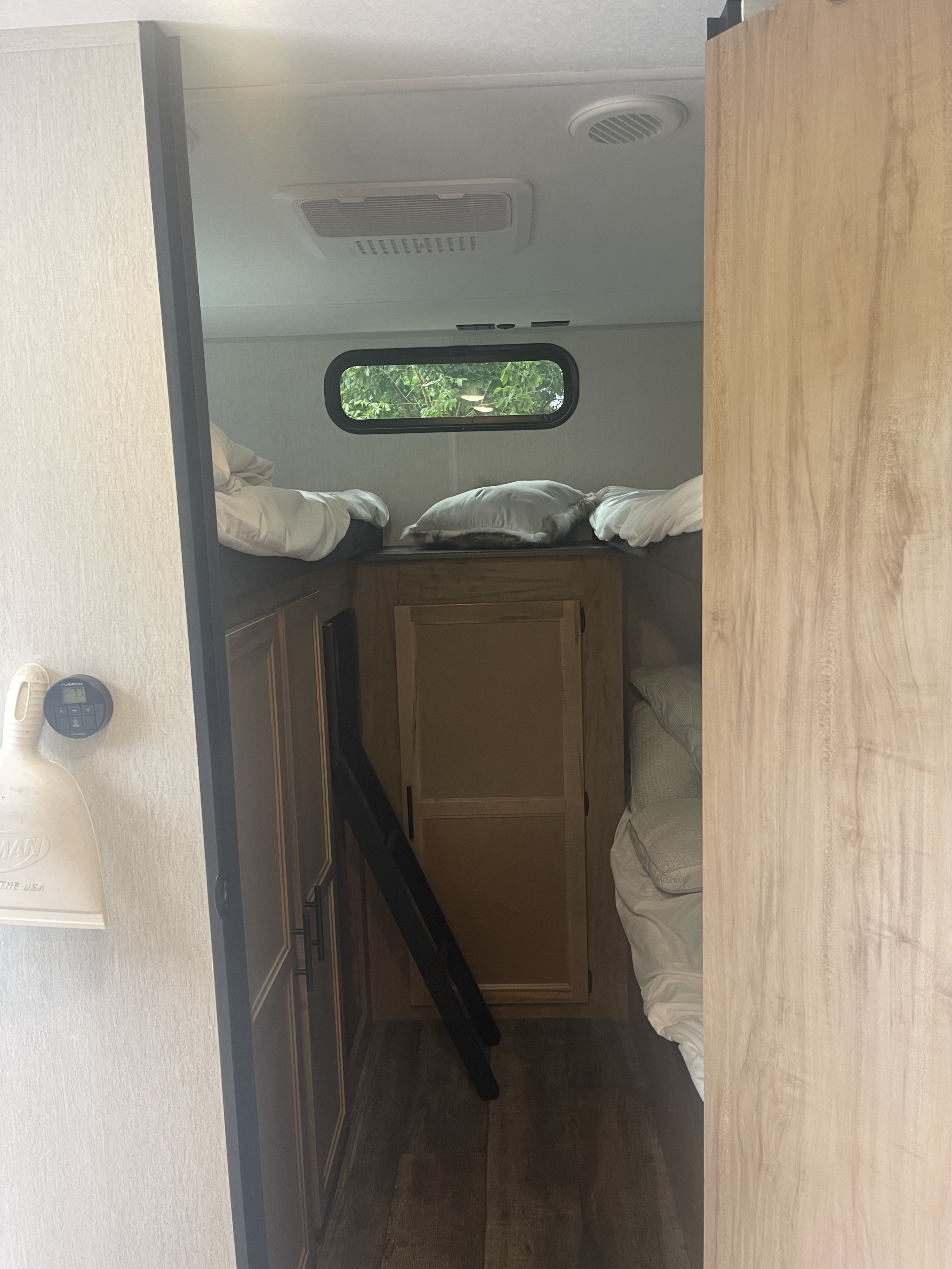 Cozy rv rental bunkhouse interior with two bunk beds, a window, AC, and a ladder.. Forest River Grey wolf 2024