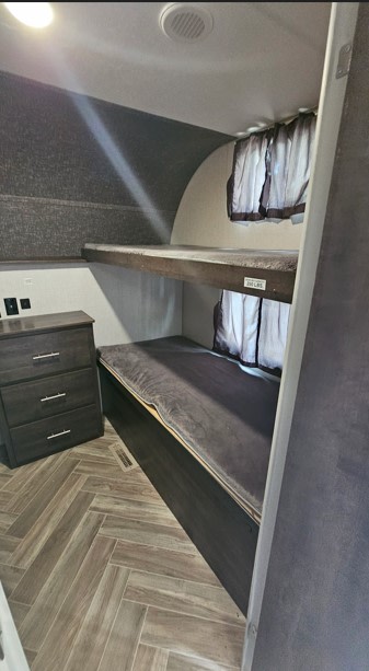 This RV rental features cozy bunk beds, a storage dresser, and stylish herringbone flooring, perfect for family adventures.. KZ 362BH 2020