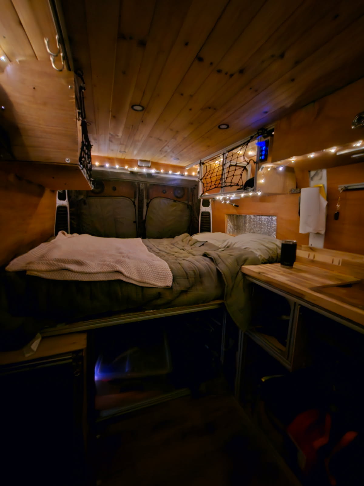 Experience a cozy RV rental adventure! This camper van features a comfy bed, wood-paneled interior, and ambient lighting.. Dodge Ram 1500 2019