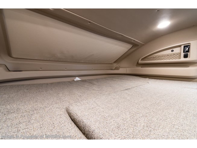 Comfortable overhead sleeping area in an RV rental, featuring a carpeted bunk, integrated light, and storage net.. Entegra Coach Odyssey 2021