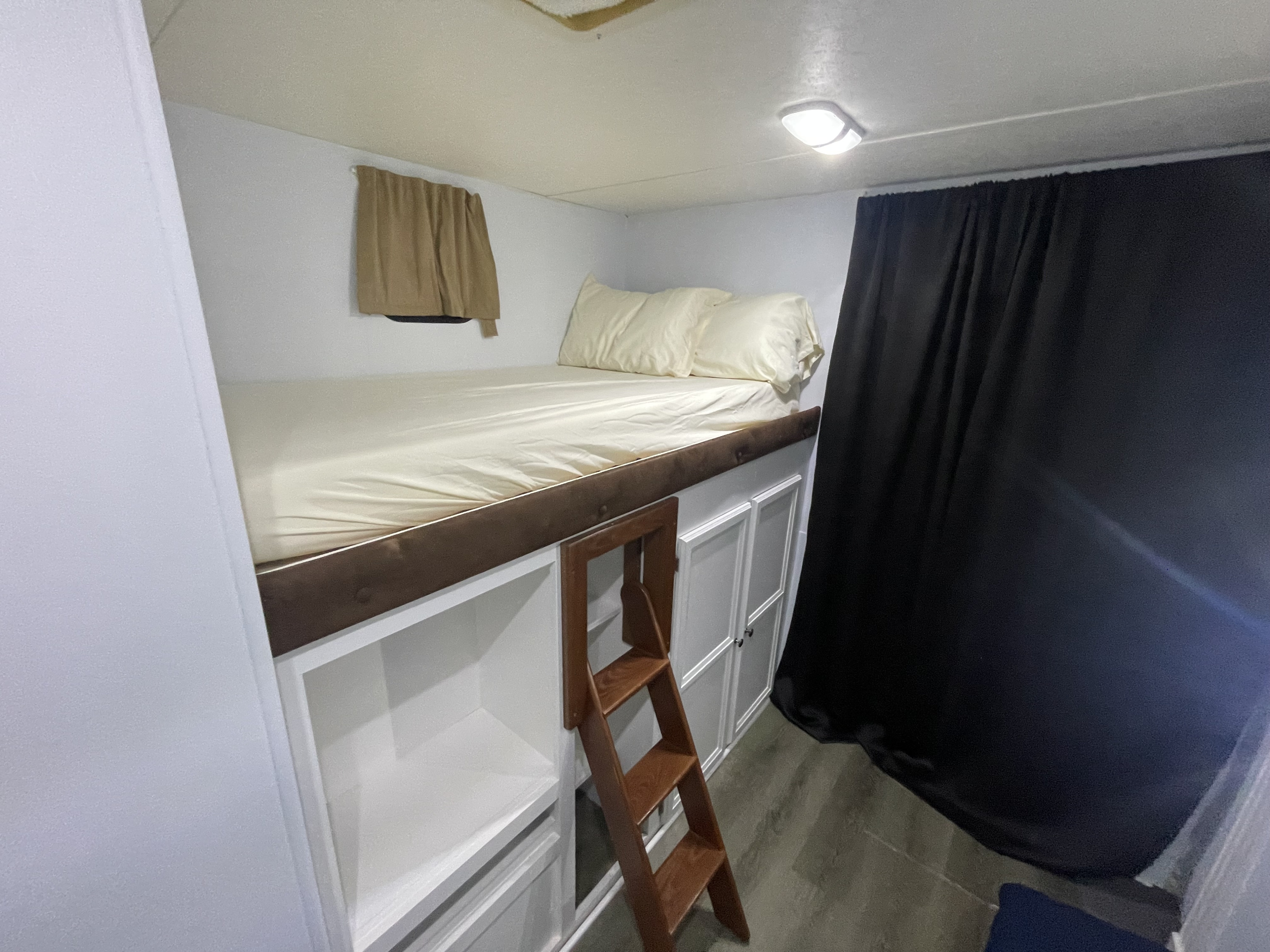 This cozy rv rental bunk bed features white bedding, a ladder, built-in storage, and dark privacy curtains.. Jayco Jay Flight 2016